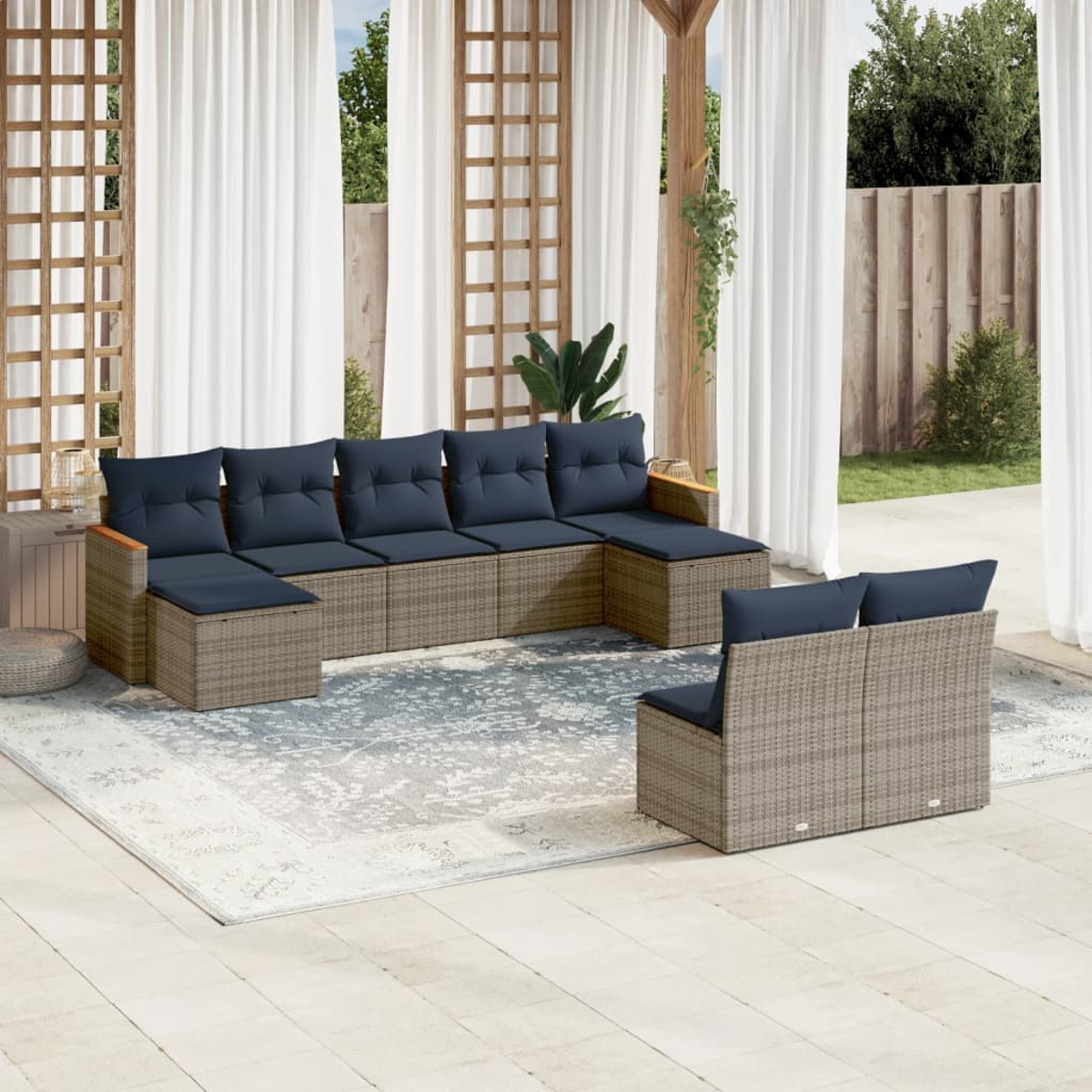Outdoor-Ecksofa mit marineblauen Kissen und einem passenden Loveseat auf einem gemusterten Teppich. Weiße Vorhänge und hölzerner Spalier im Hintergrund.