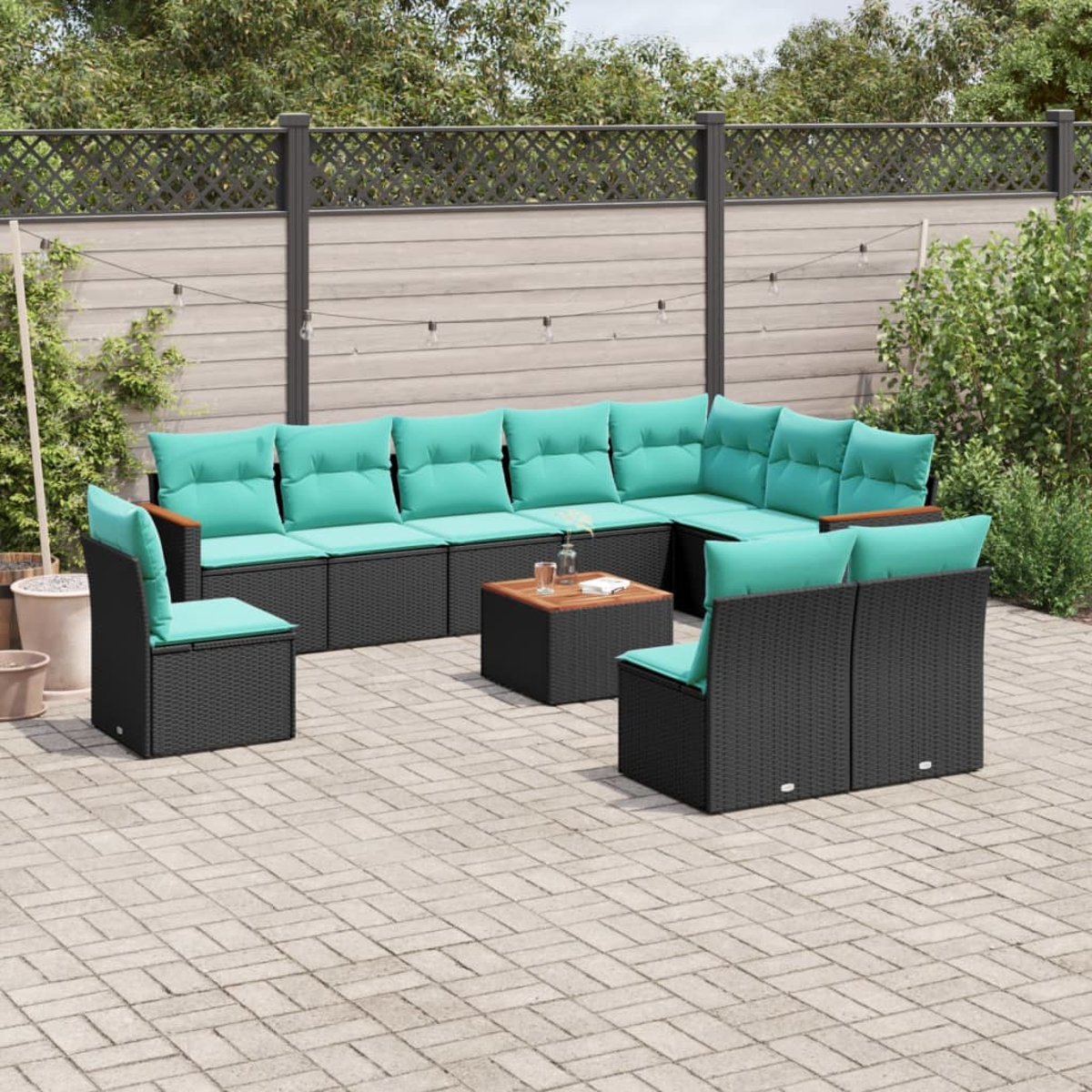 Gartenmöbel-Set. Es beinhaltet ein Ecksofa, zwei Stühle und einen Couchtisch, alles auf einer Steinterrasse.