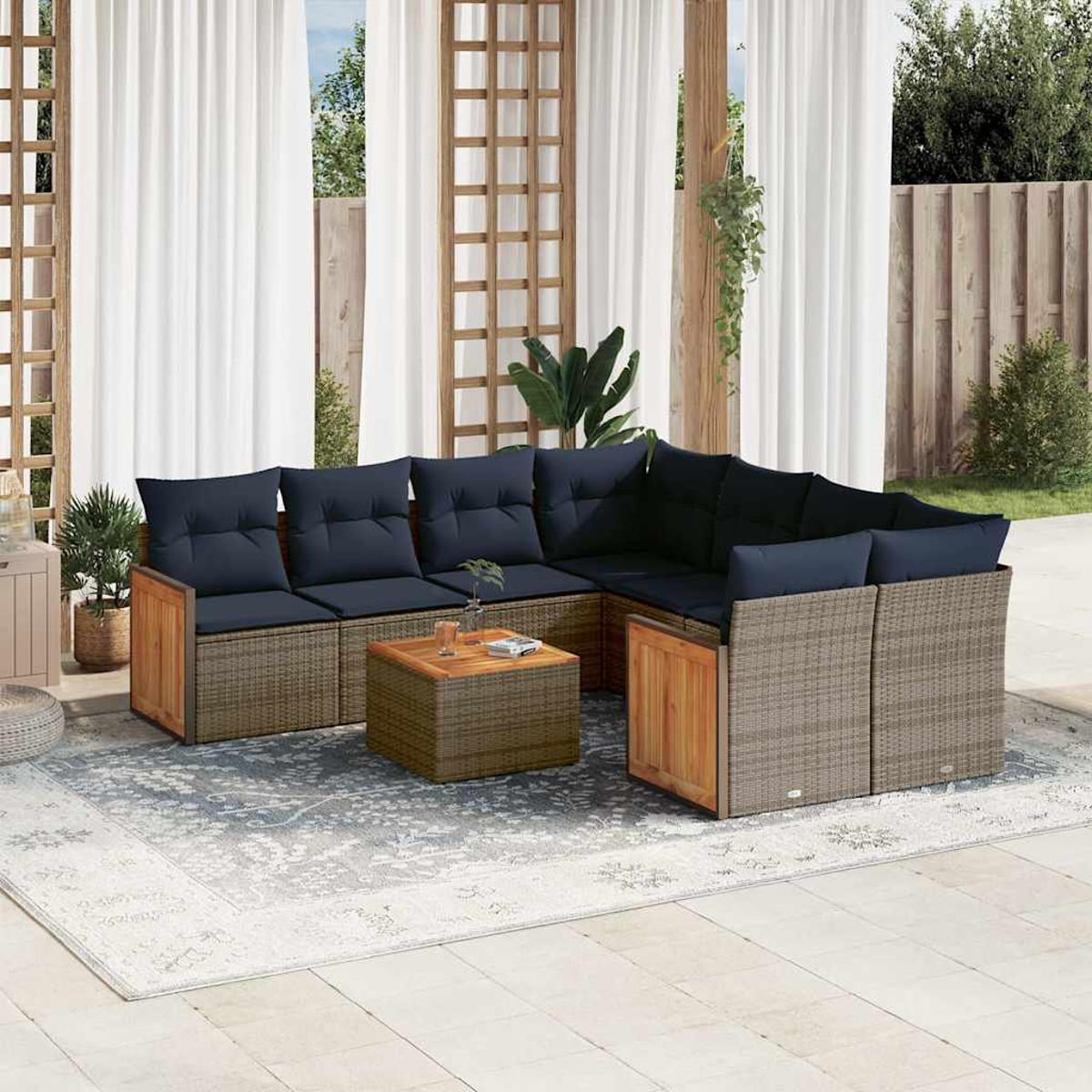 Outdoor-Ecksofa mit blauen Kissen und Holzakzenten. Davor steht ein kleiner Tisch. Im Hintergrund weiße Vorhänge und ein Holzzaun.