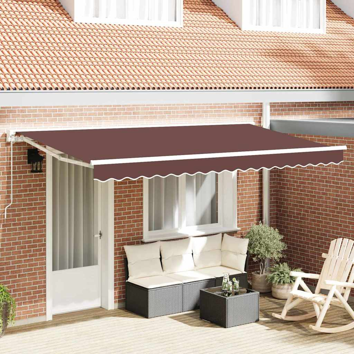 Ein brauner Markisen bedeckt eine Terrasse mit Sofa, Tisch und Schaukelstuhl. Im Hintergrund befinden sich eine Backsteinmauer und ein Dach.