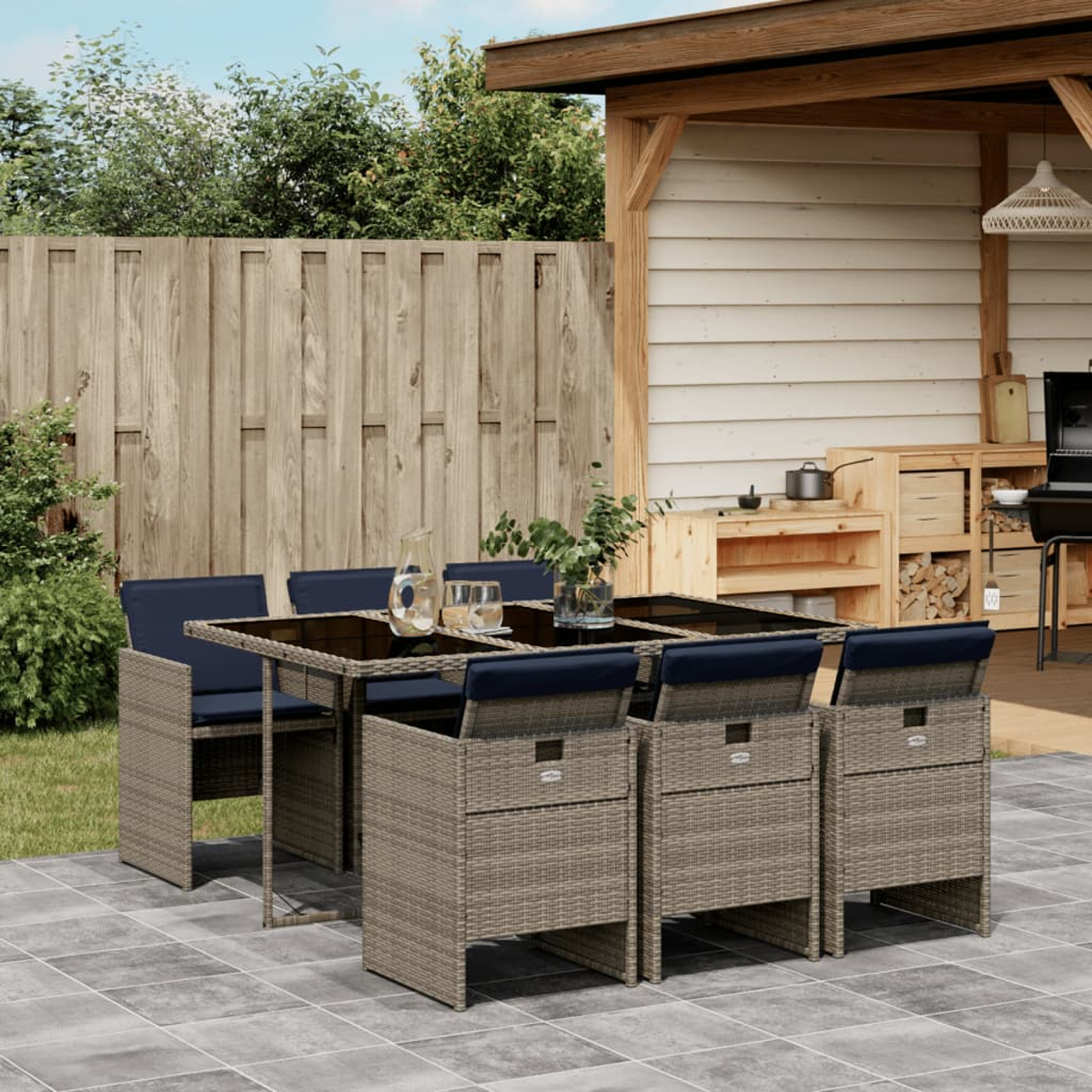 Gartenmöbel-Set mit Tisch und Stühlen. Umfasst einen Holzzaun, eine Pergola und einen Grill.