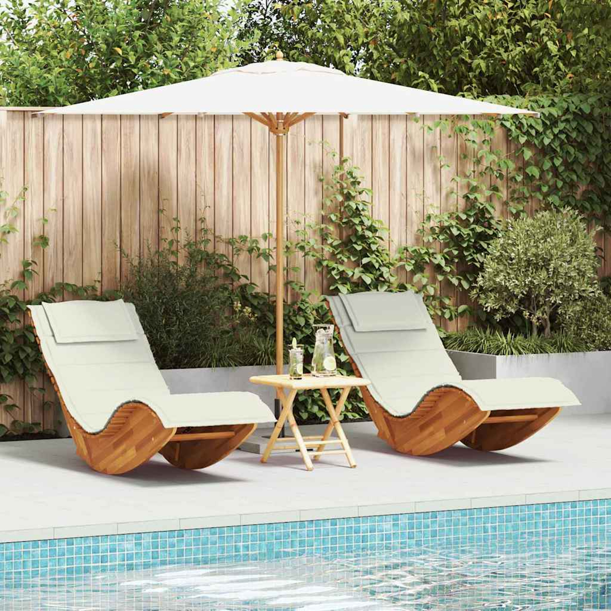 Zwei Liegestühle am Pool, unter einem Sonnenschirm, mit einem kleinen Tisch mit Getränken. Holzzaun und Grün im Hintergrund.