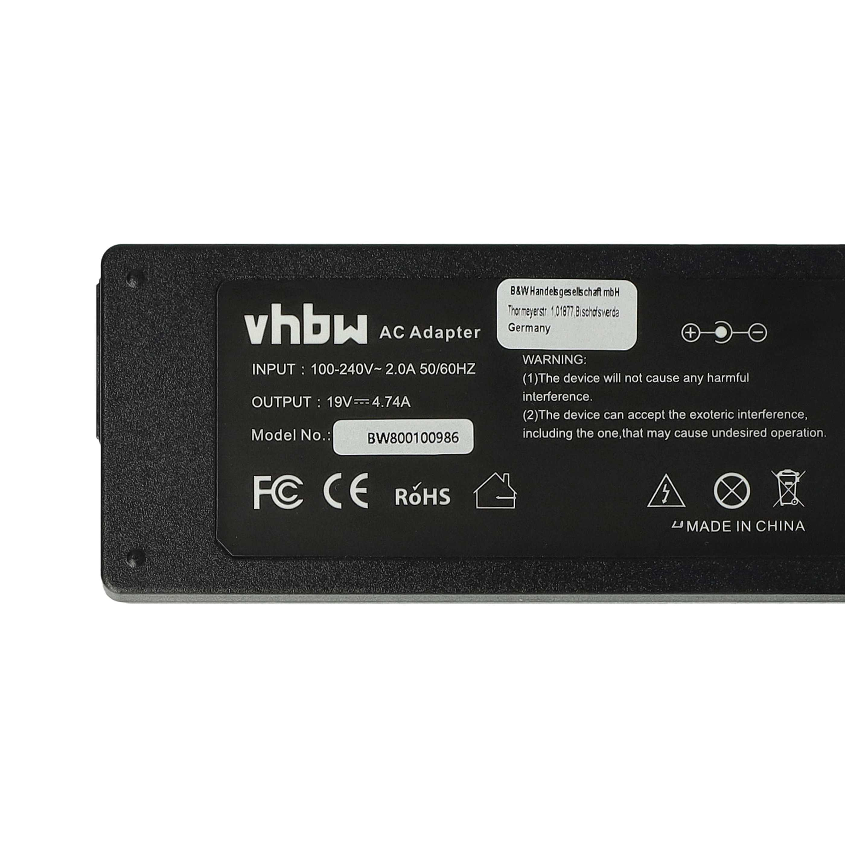 Schwarzer AC-Adapter mit weißem Text. Details umfassen Eingabe/Ausgabe, Modellnummer und Warnhinweise, mit verschiedenen Symbolen.