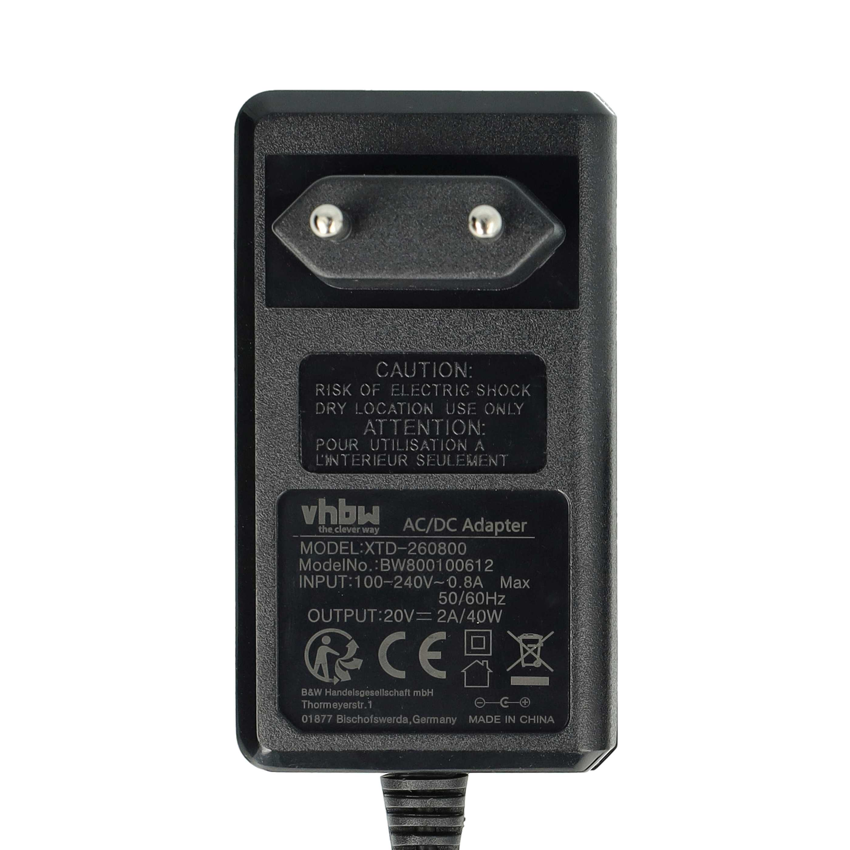 Schwarzes AC/DC-Netzteil mit Stecker, Textetiketten und Warnhinweisen. Weißer Hintergrund. Modellnummer und Herstellerinfo.