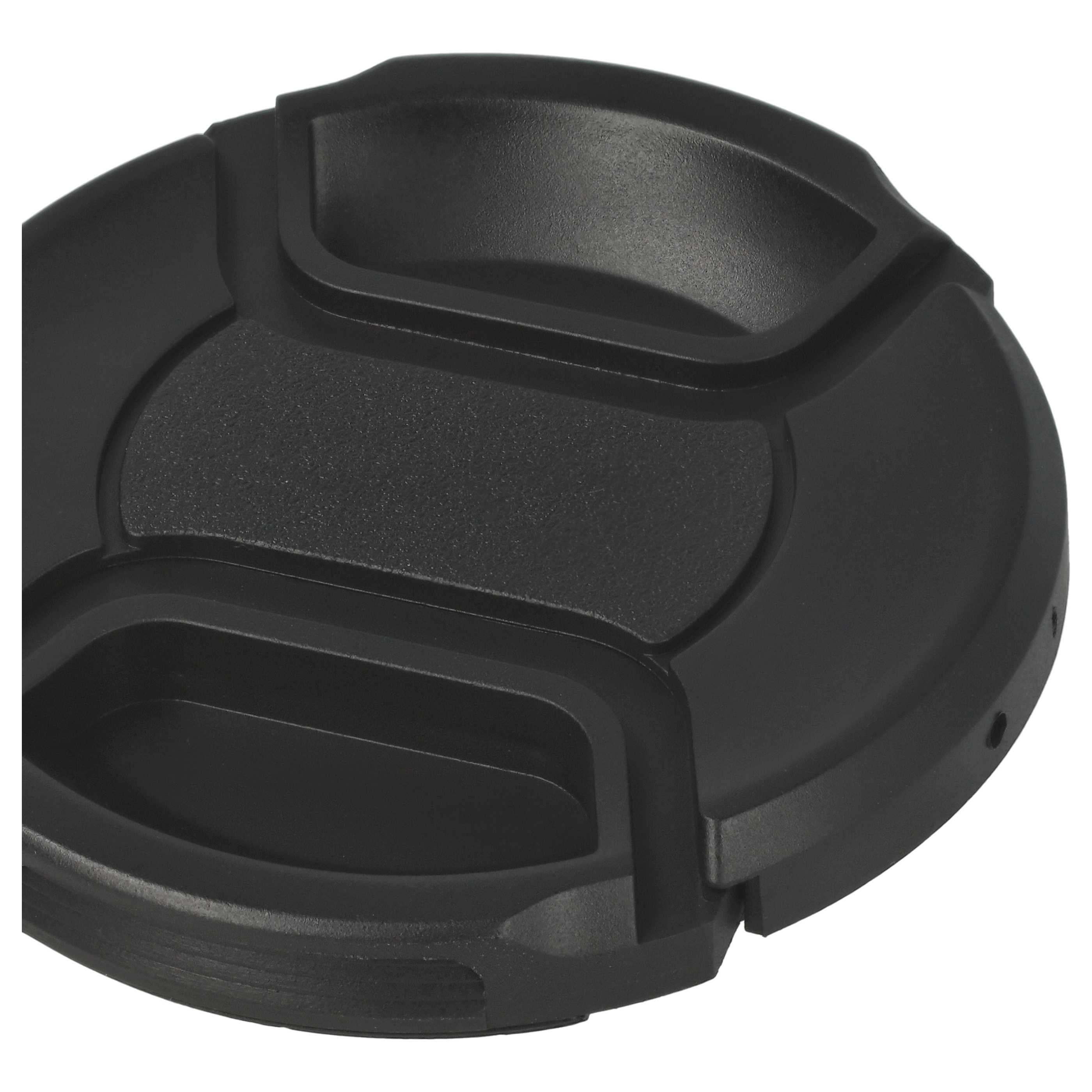 Eine schwarze Objektivkappe liegt auf weißem Grund. Sie hat eine runde Form mit strukturierter Oberfläche und mehreren Aussparungen.