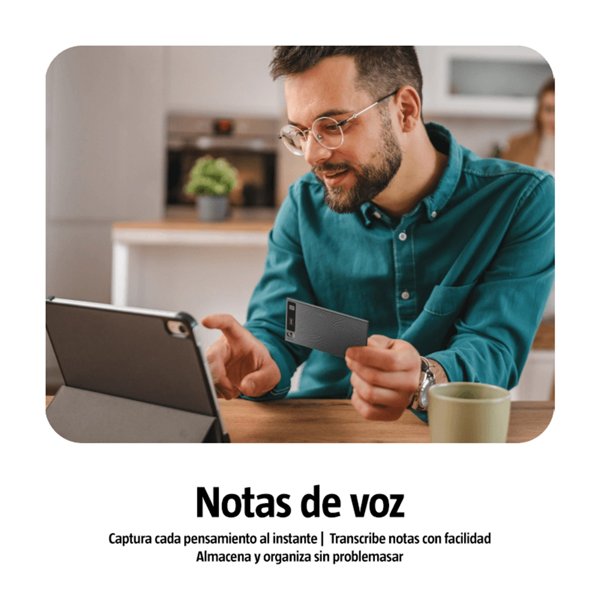 Un hombre con gafas usa una tableta y sostiene una tarjeta. Una taza verde está a la derecha.