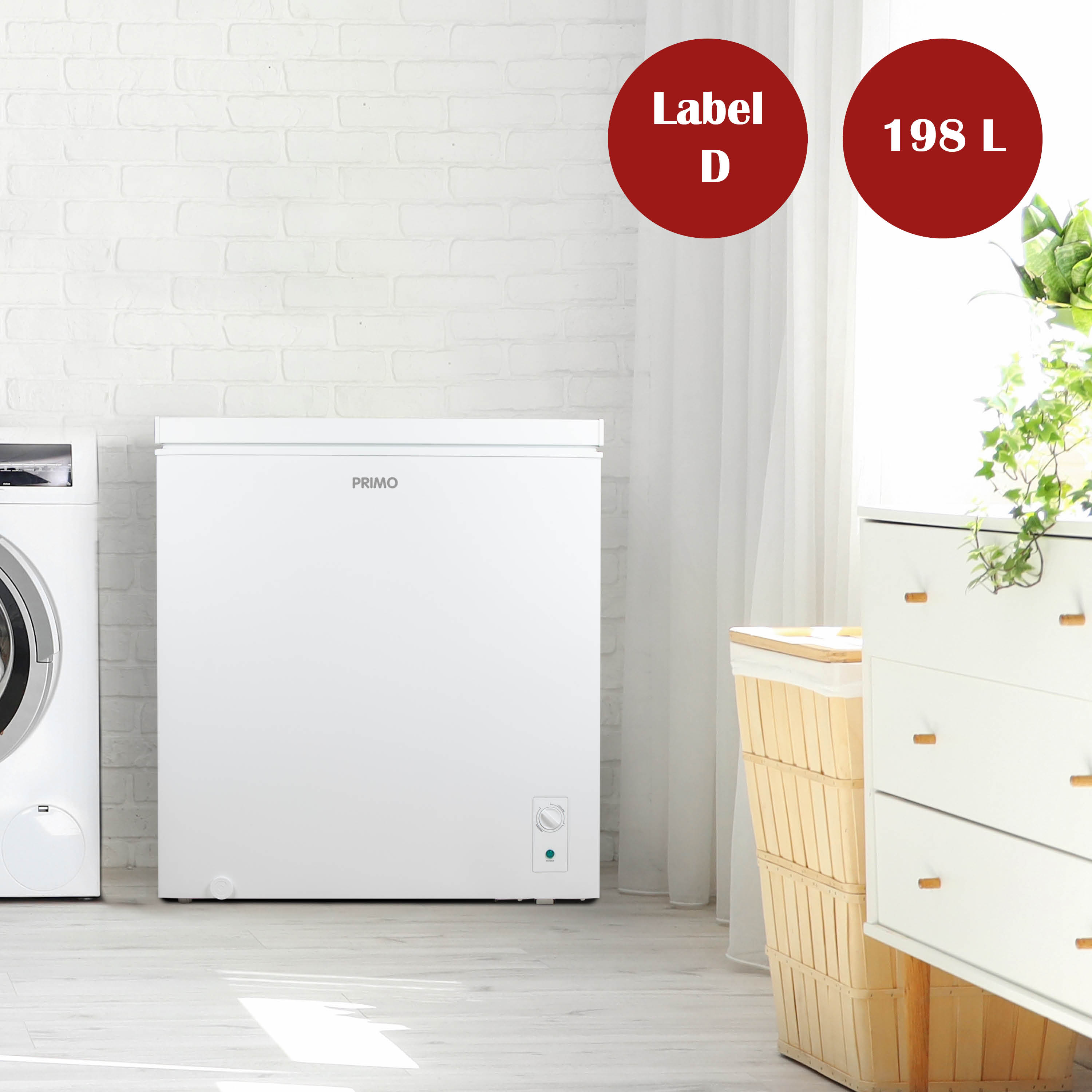 Een witte vrieskist van het merk PRIMO staat in een kamer. Een wasmachine, een dressoir en een mand zijn ook zichtbaar.