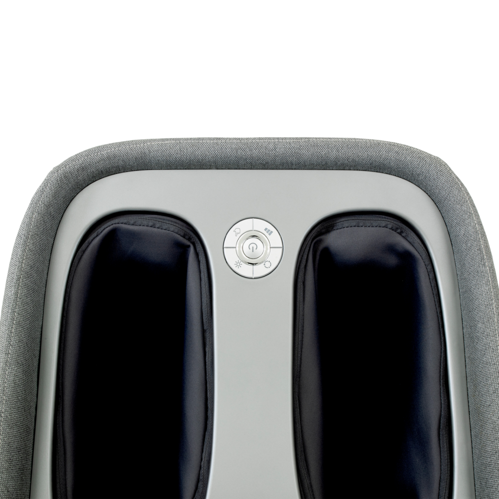 Close-up van een grijze voetmassager. Het heeft twee zwarte voetvakken en een bedieningspaneel met diverse knoppen. De achtergrond is wit.