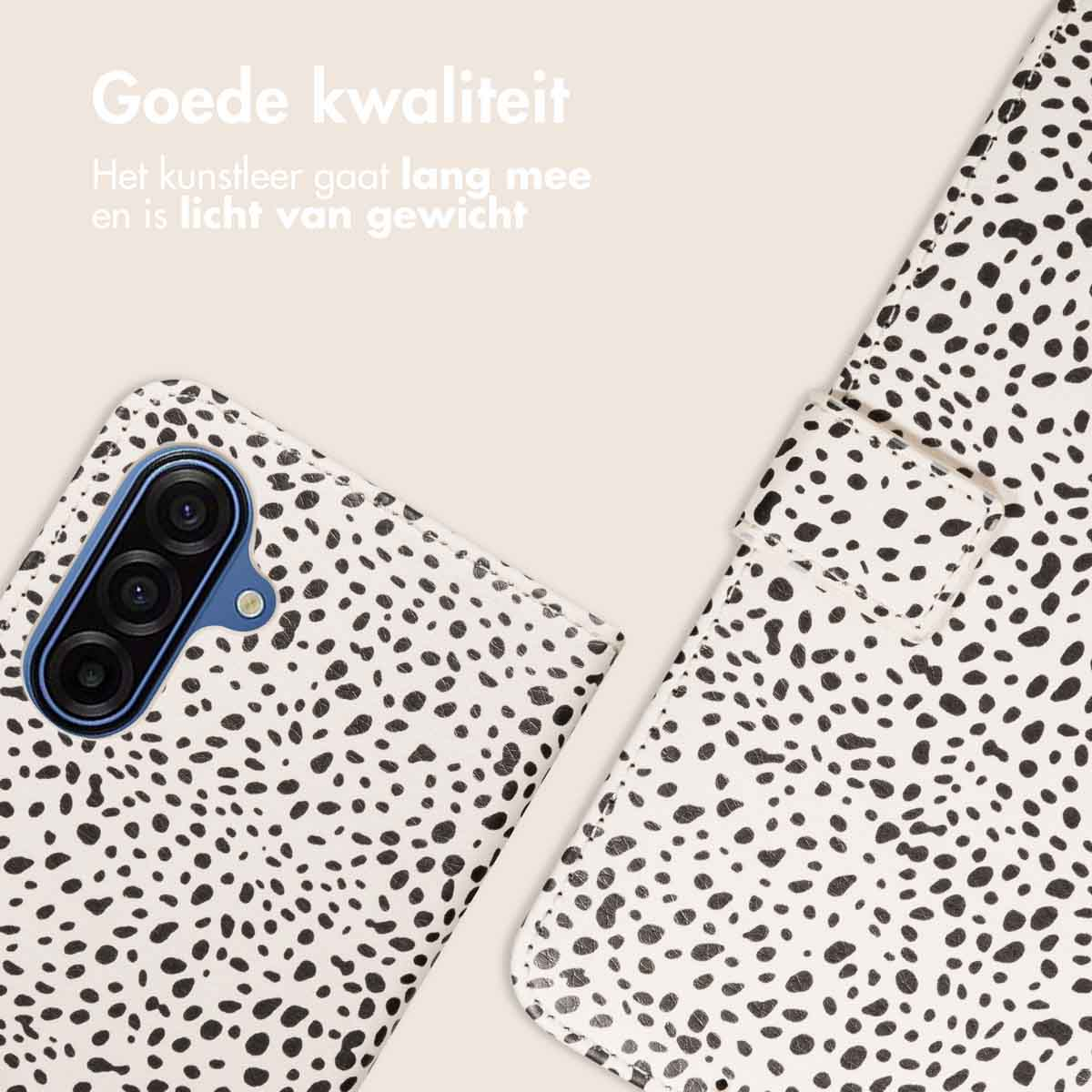 Witte telefoonhoes met zwarte stippen. Deels een telefoon en een hoesje zichtbaar. De achtergrond is lichtbeige.