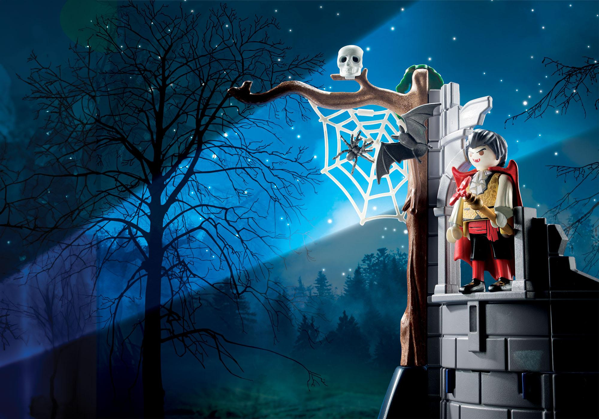 Zabawka wampira stoi na murze zamku. Pajęczyna i nietoperz są na gałęzi. Czaszka zdobi gałąź. Drzewo jest na pierwszym planie.