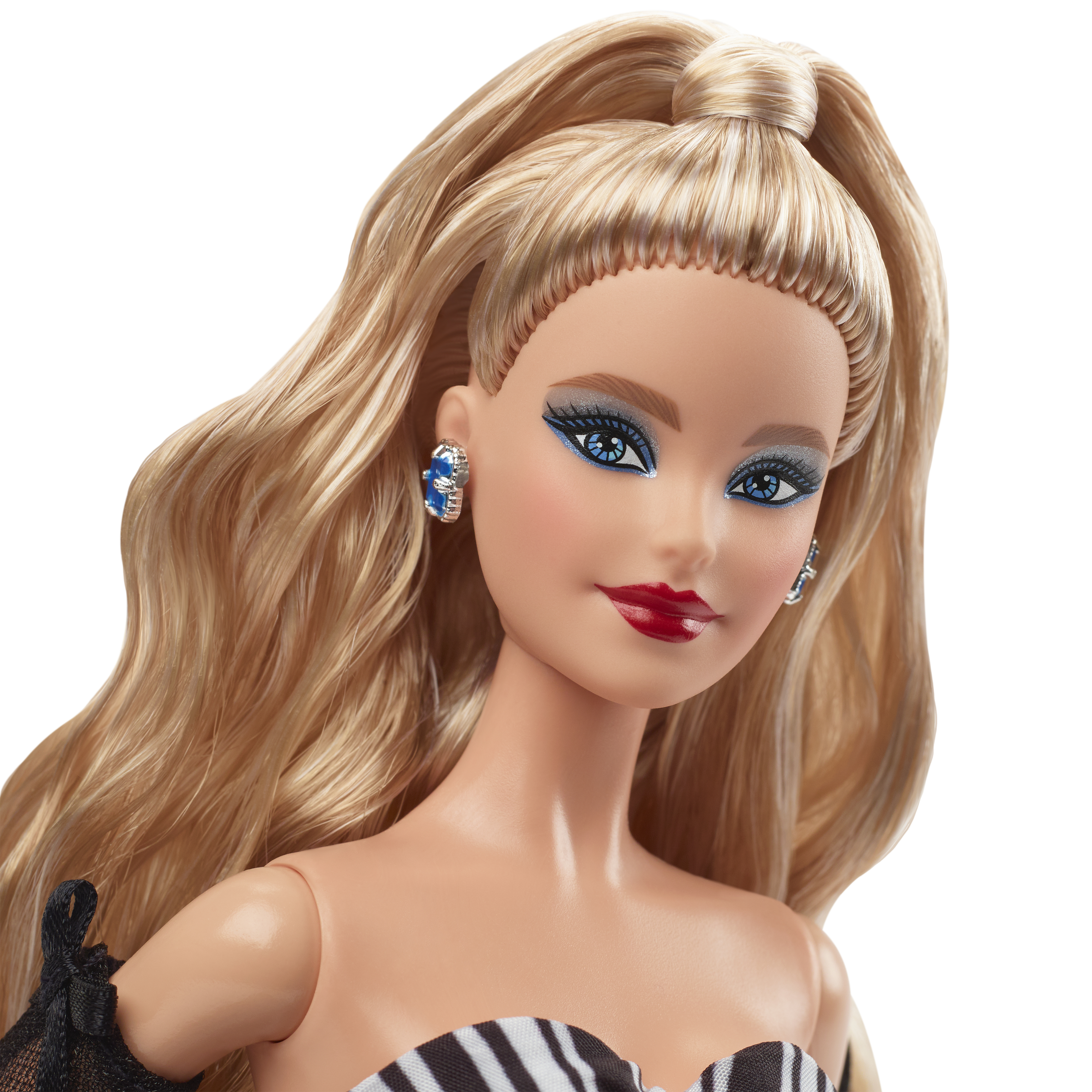 Una muñeca Barbie con cabello rubio, sombra de ojos azul, lápiz labial rojo y aretes. Lleva un vestido a rayas blanco y negro.