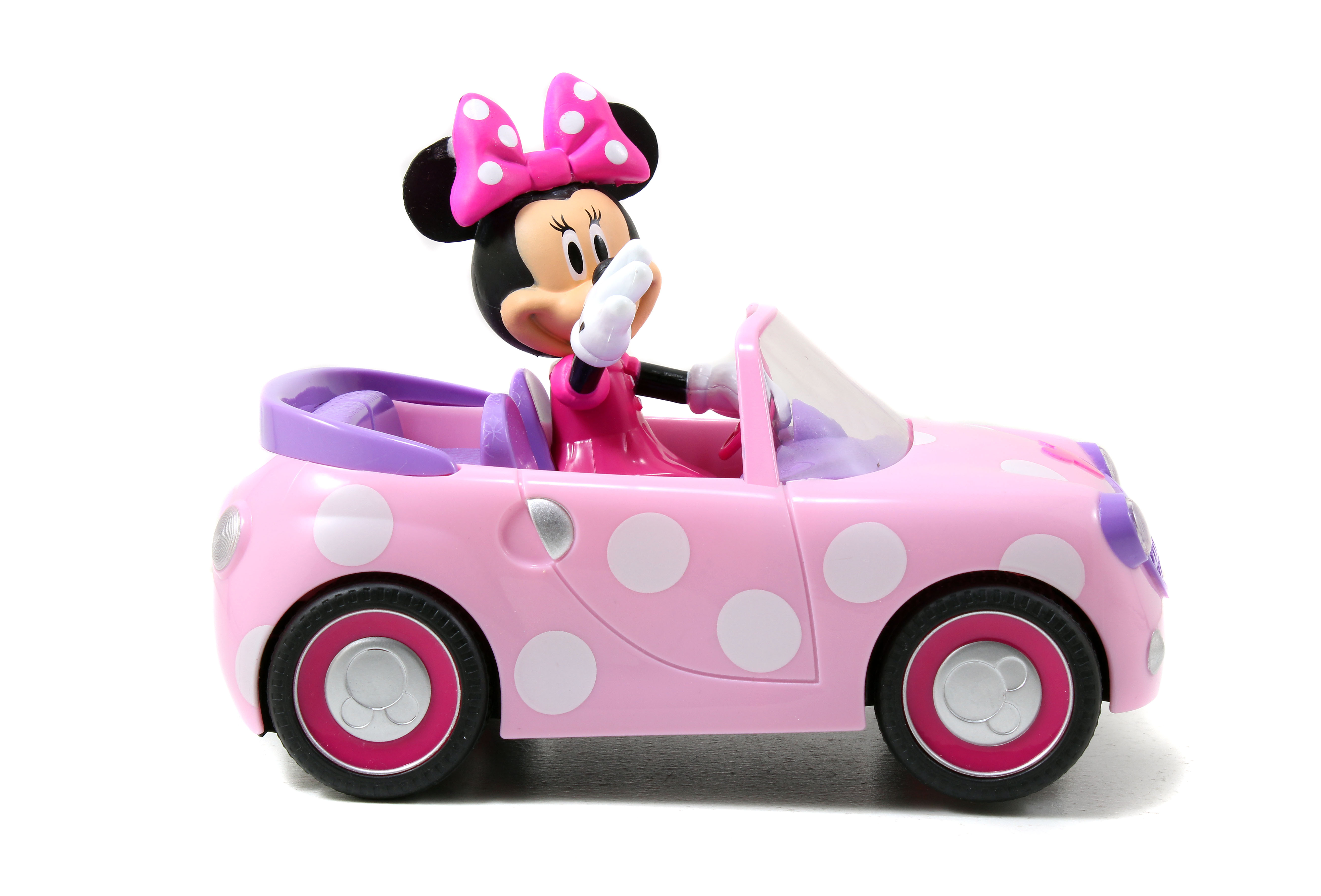 Minnie Mouse en un descapotable rosa. El coche tiene lunares blancos. Minnie usa un vestido y un lazo rosas.