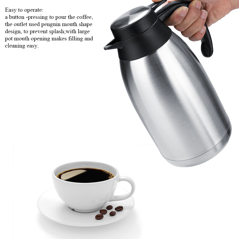 Eine silberne Thermoskanne wird über einer weißen Tasse mit Kaffee und Untertasse gehalten. Kaffeebohnen liegen in der Nähe, weißer Hintergrund.