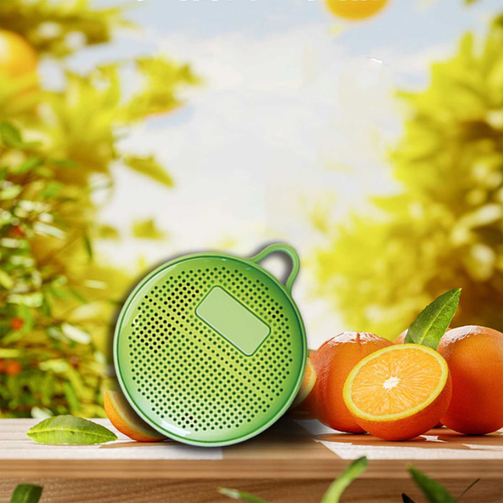 Ein grüner Lautsprecher mit Orangen. Eine Orange ist halbiert. Grüne Blätter und ein gelber Hintergrund.
