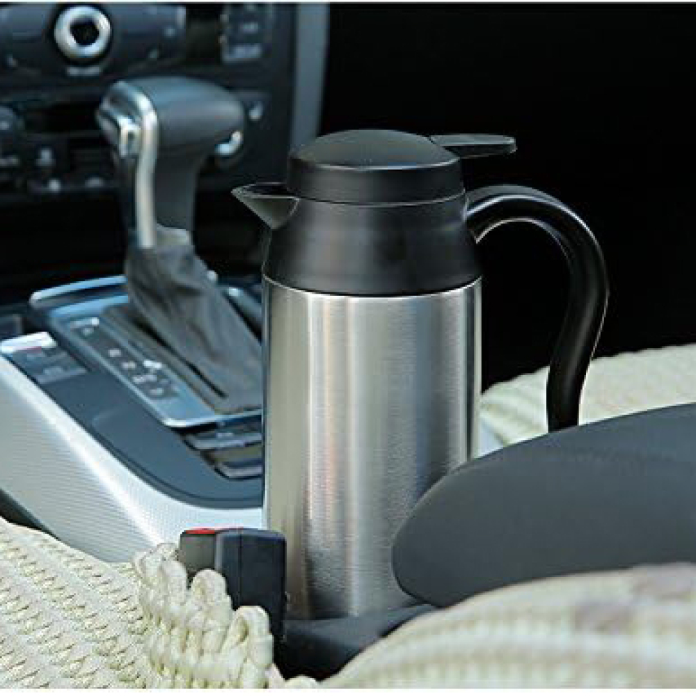 Eine Edelstahl-Thermoskanne mit schwarzem Deckel und Griff steht in einem Auto. Der Hintergrund zeigt den Innenraum des Autos.