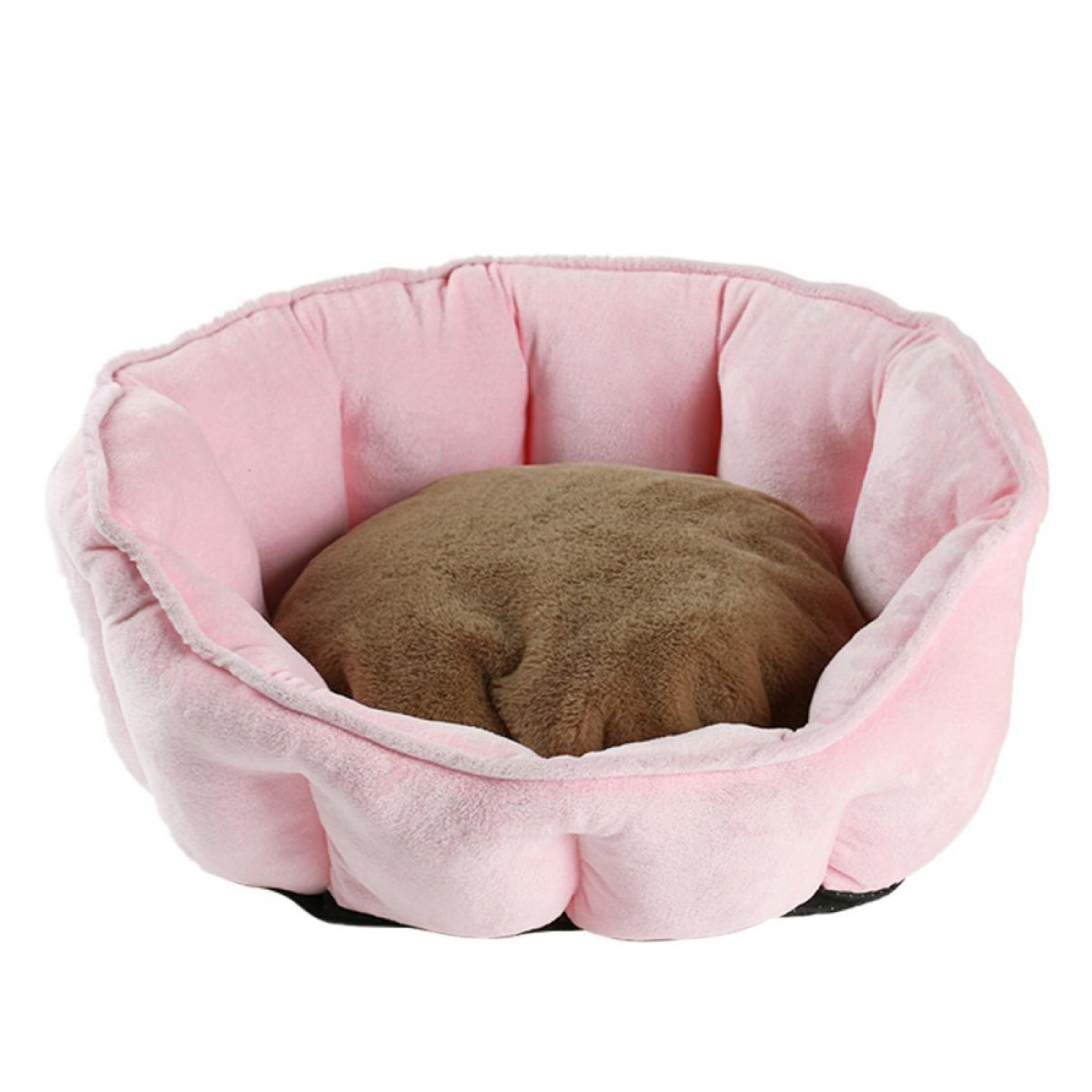 Ein rosa Haustierbett mit einem braunen Kissen. Das Bett hat ein blütenblattartiges Design, der Hintergrund ist weiß.