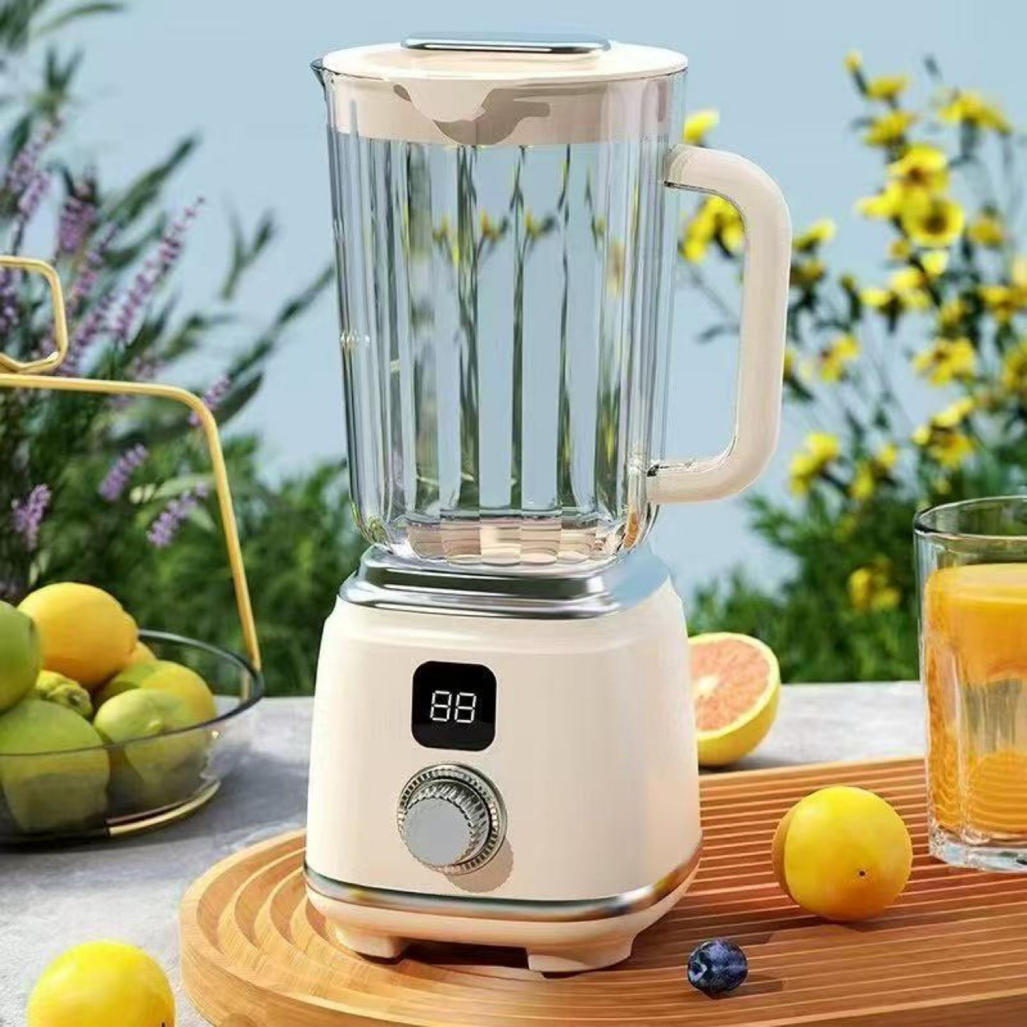 Ein beiger Mixer steht auf einem Holztablett mit Obst und einem Glas Saft. Blumen sind im Hintergrund.