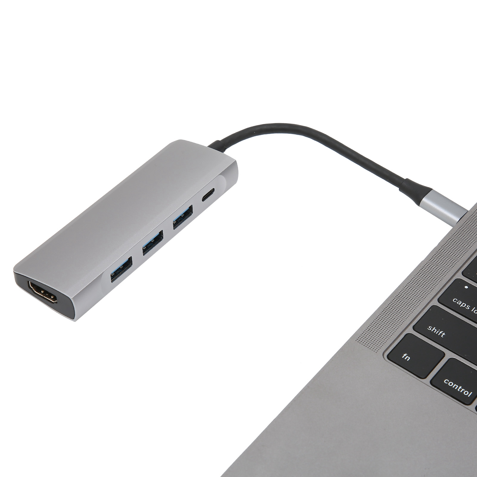 Ein silberner USB-C-Hub mit Anschlüssen ist mit einem Laptop verbunden. Der Hub hat HDMI- und USB-Anschlüsse. Der Hintergrund ist weiß.