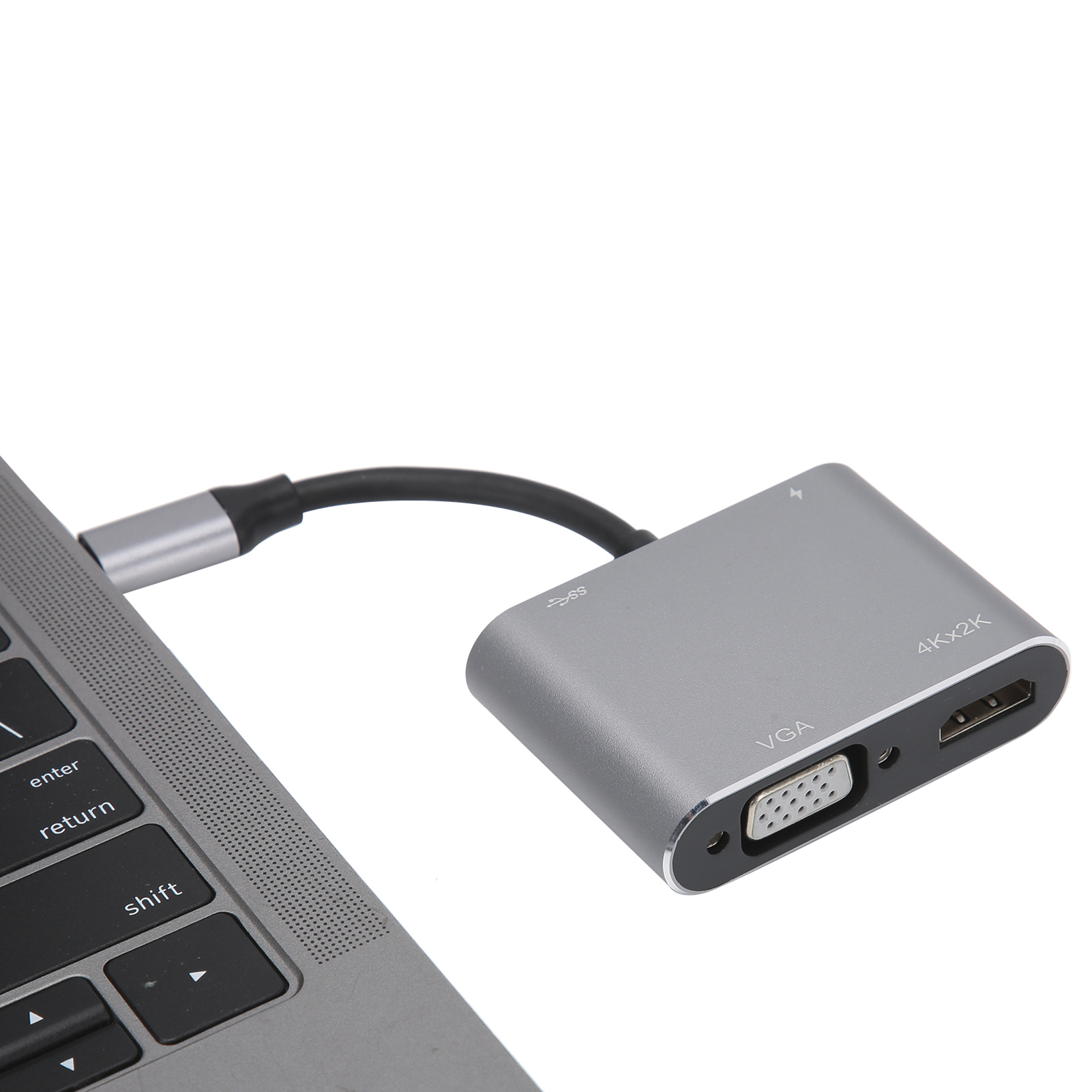 Ein silberner USB-C-Hub ist mit einem Laptop verbunden. Er hat VGA-, HDMI-Anschlüsse. Die Tastatur ist sichtbar.