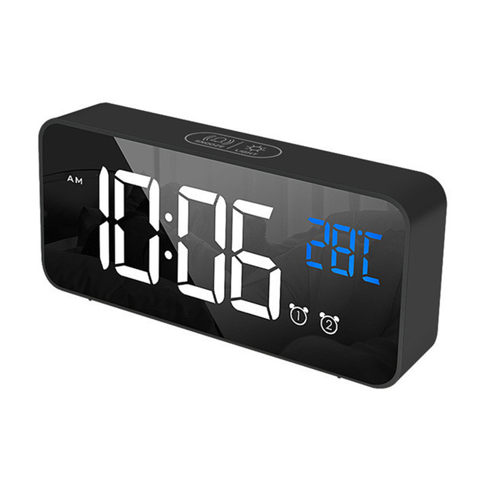 Ein schwarzer digitaler Wecker zeigt 10:06 Uhr und 28 °C an. Er hat eine verspiegelte Oberfläche mit Tasten für Einstellungen und Alarme.