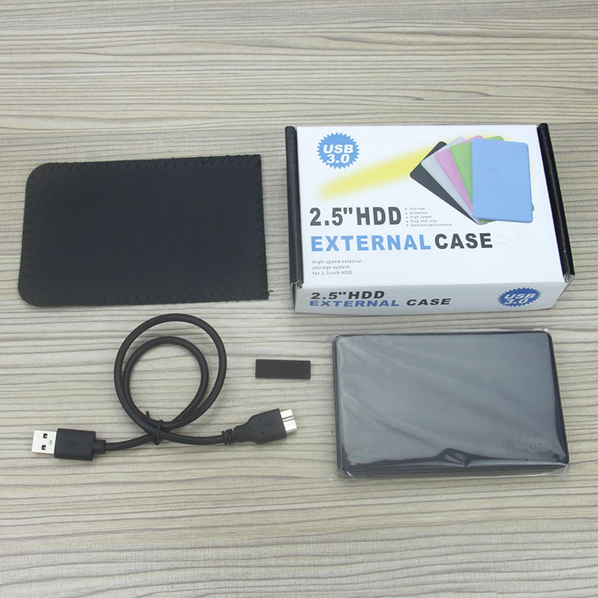 Ein externes Festplatten-Kit mit schwarzem Gehäuse, USB-Kabel und einer Box auf einer Holzoberfläche.
