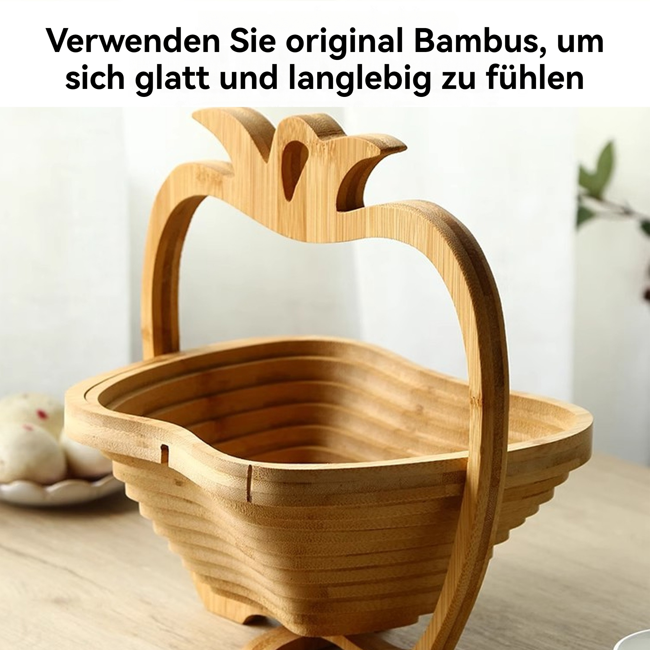 Ein hölzerner Bambus-Obstkorb steht auf einem Tisch. Er hat einen Griff und ein geschichtetes Design. Ein Teller mit Essen ist im Hintergrund.