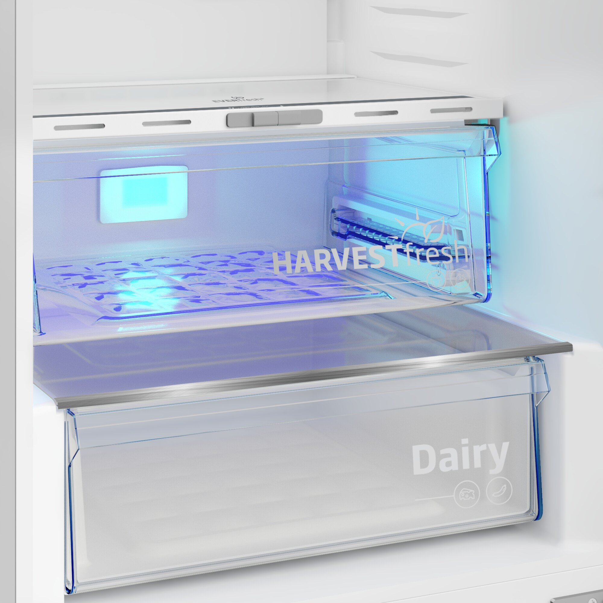 Interior de un refrigerador con un cajón de productos iluminado en azul con la etiqueta "HARVESTfresh" y un cajón inferior con la etiqueta "Dairy".