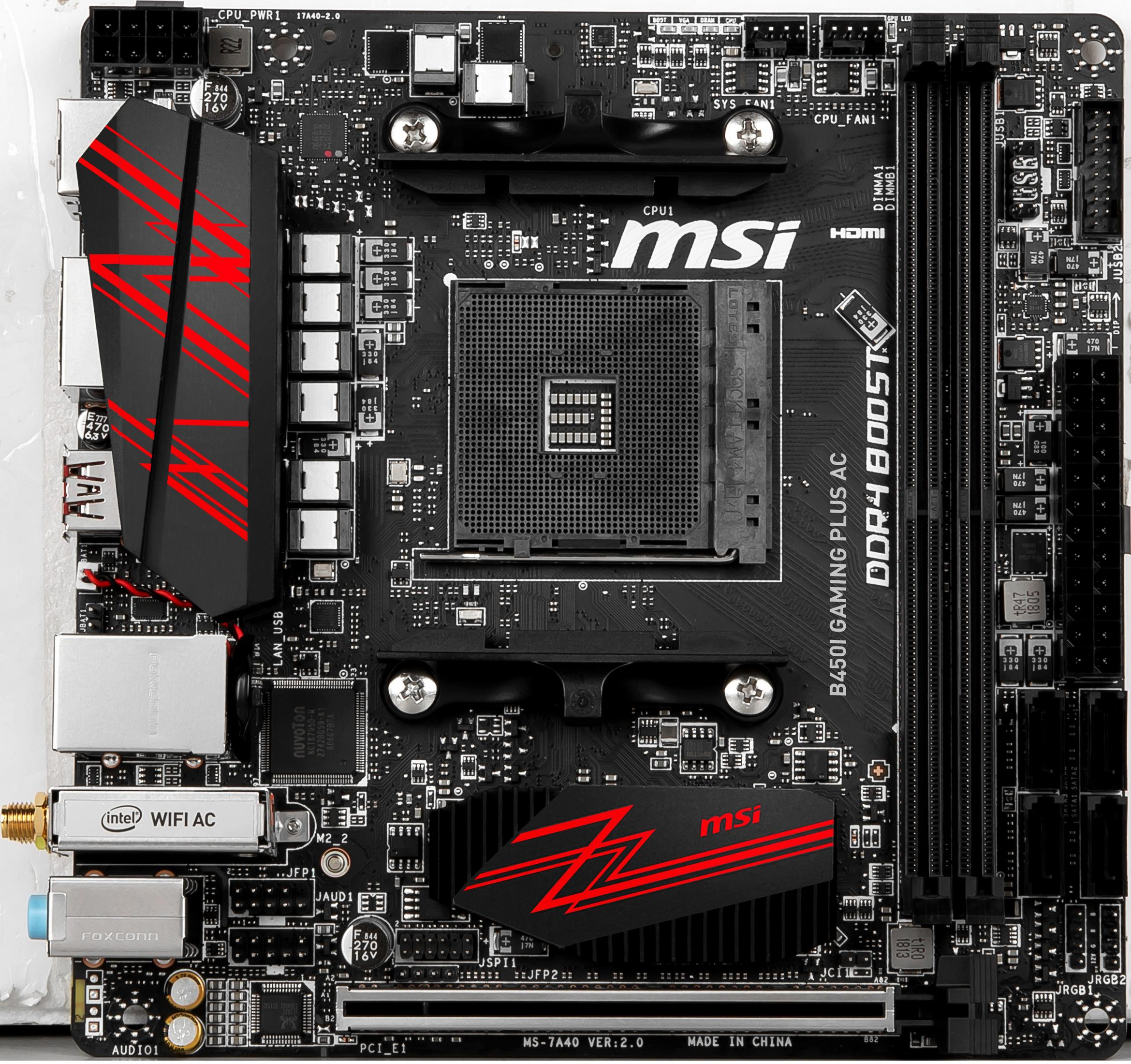 Ein schwarzes MSI B450I Gaming Plus AC Motherboard mit roten Akzenten, verschiedenen Steckplätzen und dem MSI-Logo.