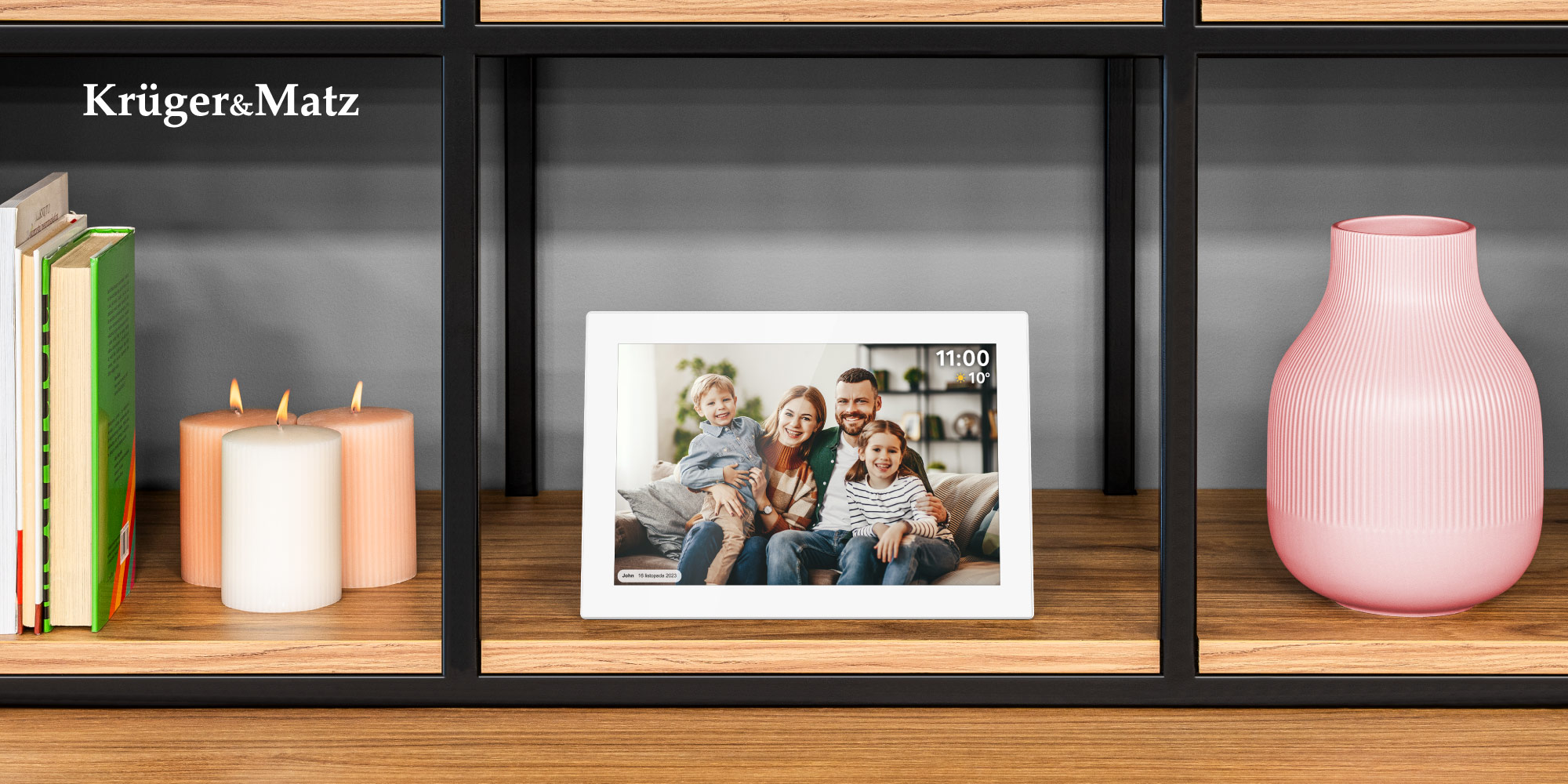 Półka z cyfrową ramką na zdjęcia przedstawiającą rodzinę, świece, książki i różowy wazon. Logo znajduje się w lewym górnym rogu.