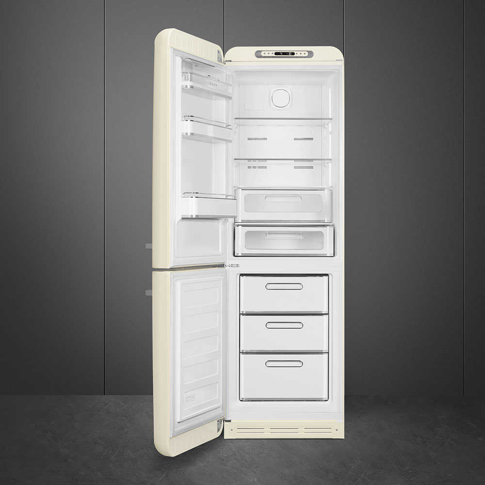 Cremefarbener Kühlschrank mit geöffneten Türen. Innenregale, Schubladen und Fächer sind sichtbar. Dunkelgraue Wand im Hintergrund.