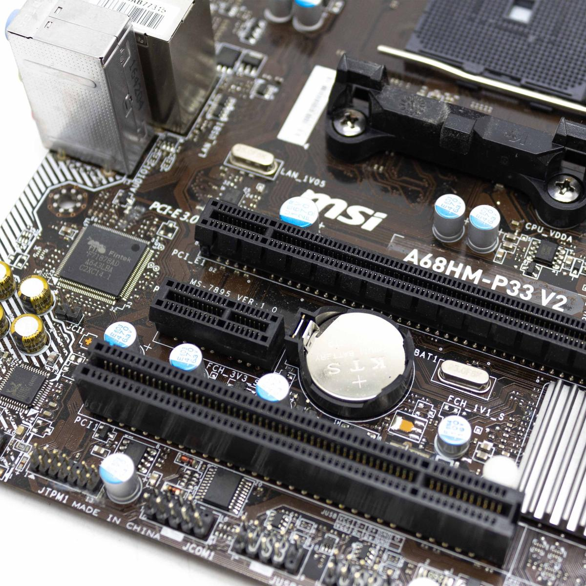 Primo piano di una scheda madre del computer. Presenta vari componenti, slot e una batteria. La scheda è marrone e nera.