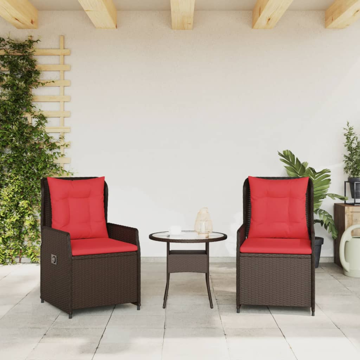 Zwei braune Korbstühle mit roten Kissen und ein kleiner runder Tisch stehen auf einer Terrasse. Grüne Pflanzen und Holzbalken sind im Hintergrund.
