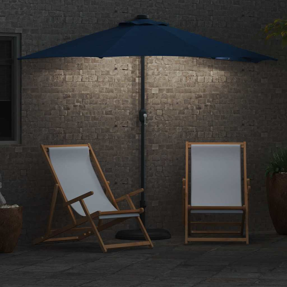Due sedie con seduta bianca e un ombrellone blu si trovano su un patio in mattoni. La scena è illuminata da una luce dall'alto.