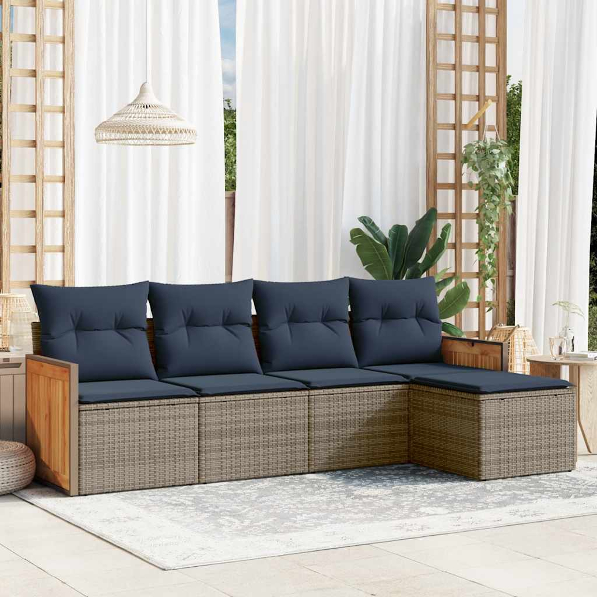 Ein Ecksofa im Freien mit marineblauen Kissen. Das Sofa steht auf einem Teppich, mit weißen Vorhängen und einer Hängelampe im Hintergrund.