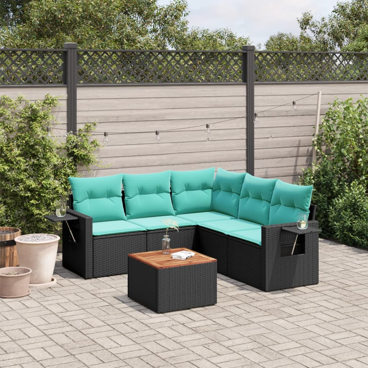 Outdoor-Ecksofa mit türkisfarbenen Kissen, schwarzem Korbgewebe und einem Holztisch auf einer Ziegelterrasse.