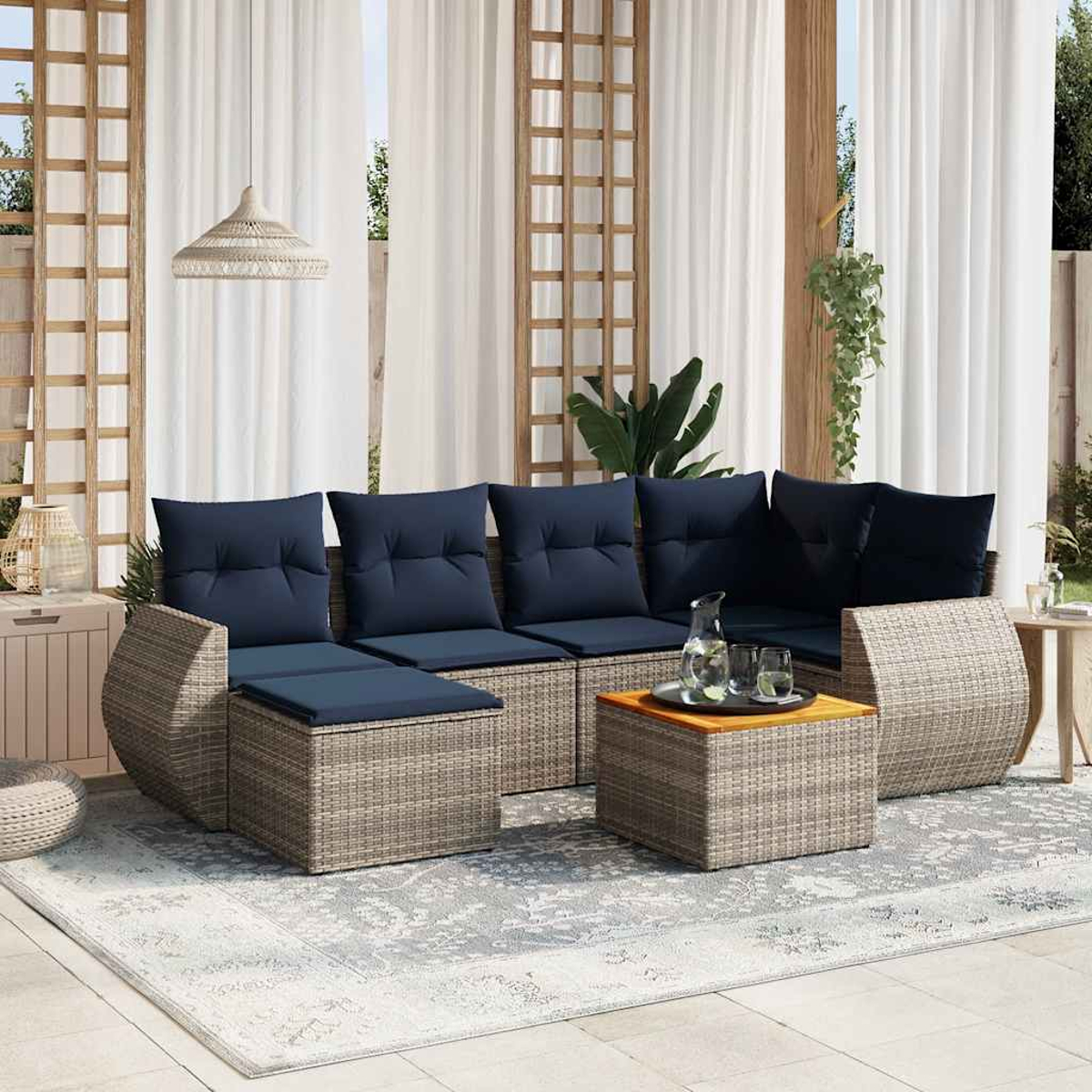 Gartensitzgruppe mit blauen Kissen. Enthält ein Sofa, Ottomanen und einen Couchtisch. Auf einem grauen Teppich, mit weißen Vorhängen im Hintergrund.