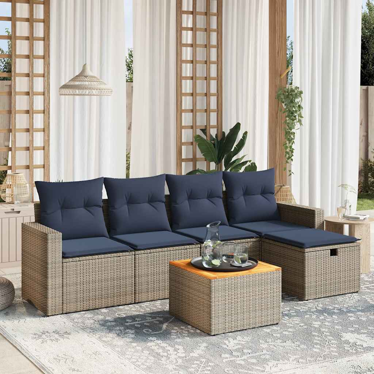 Outdoor-Korbsessel mit marineblauen Kissen. Ein quadratischer Couchtisch trägt Getränke. Weiße Vorhänge und eine gewebte Lampe hängen im Hintergrund.