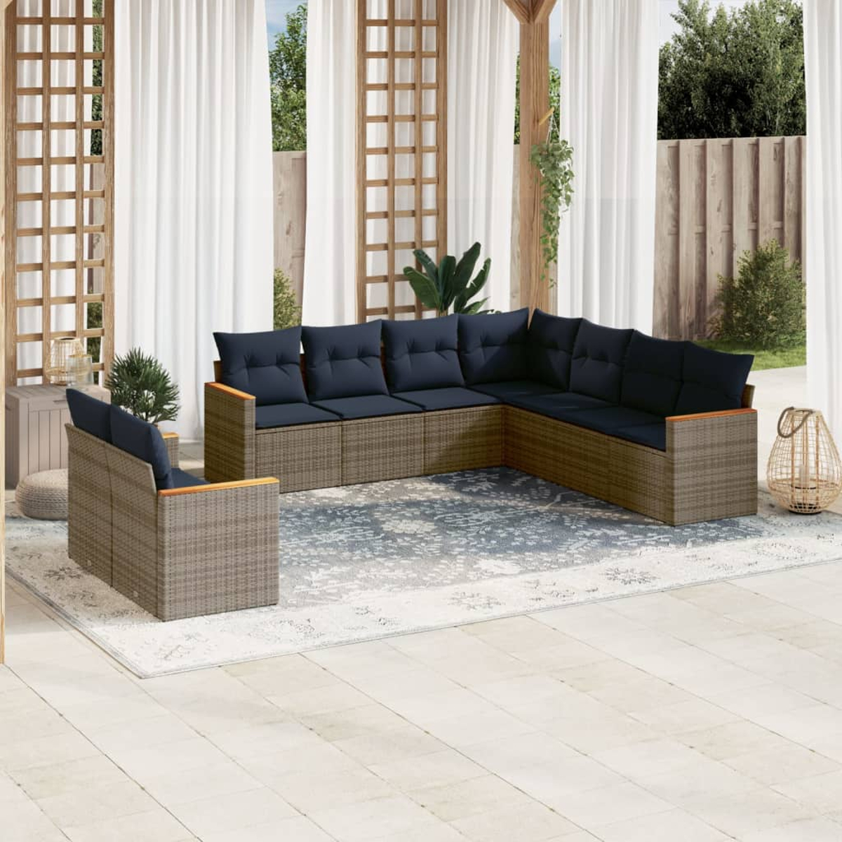 Outdoor-Ecksofa mit marineblauen Kissen, braunem Korbgewebe und Holzarmlehnen. Auf einem gemusterten Teppich, mit Vorhängen und Pflanzen.