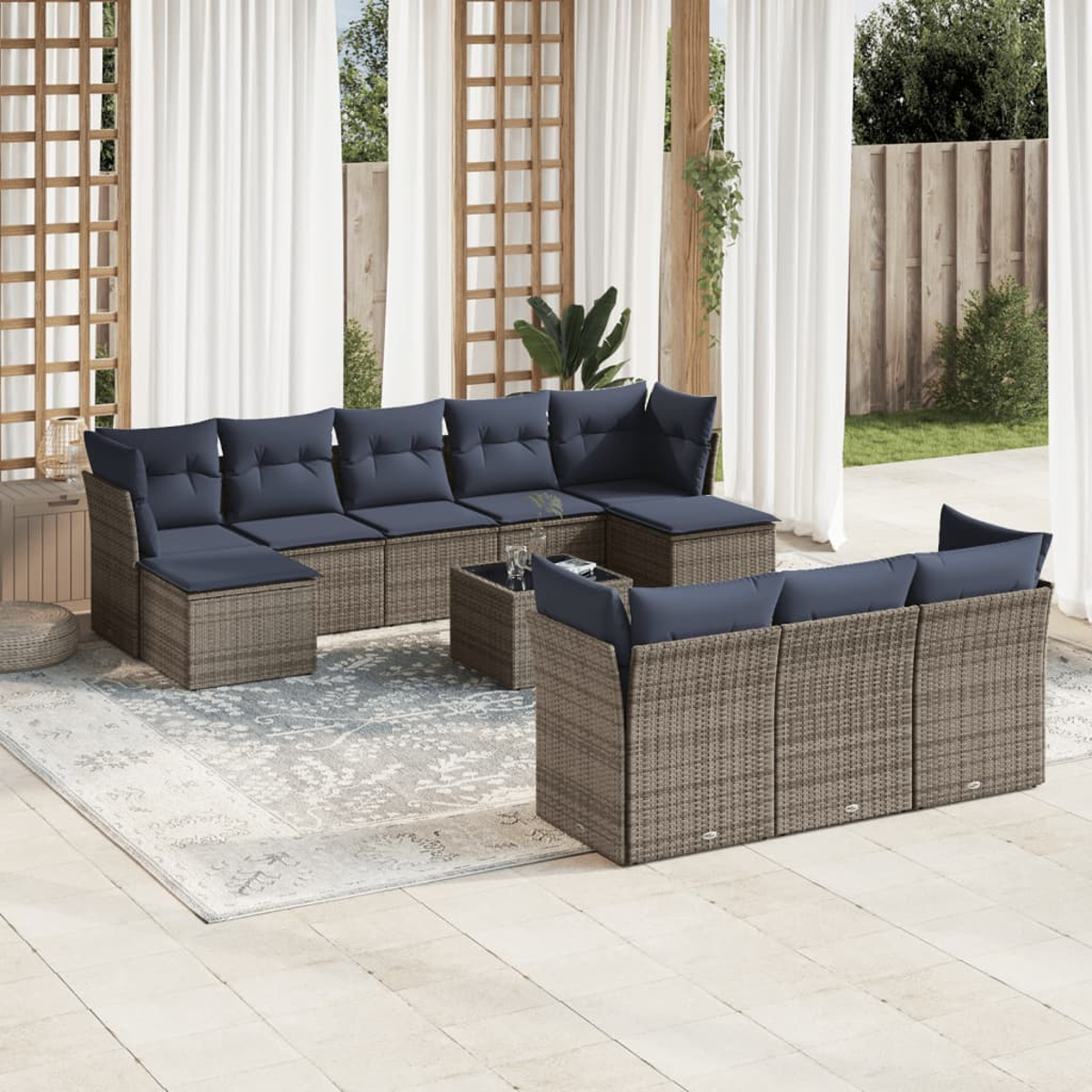 Gartenmöbel mit blauen Kissen. Enthält ein Ecksofa, einen Couchtisch und zusätzliche Sitzgelegenheiten. Auf Terrasse mit Vorhängen.