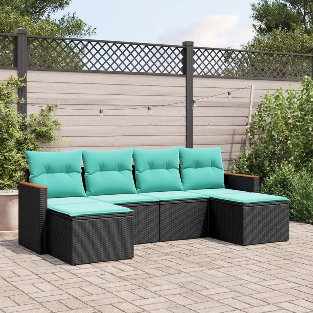 Schwarzes Outdoor-Korbmöbel mit türkisfarbenen Kissen. Holzarmlehnen. Auf einer Terrasse mit Zaun und Pflanzen im Hintergrund.