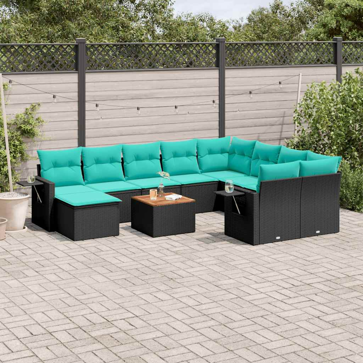 Outdoor-Ecksofa mit türkisfarbenen Kissen auf einer Terrasse. Es hat einen dunkelbraunen Couchtisch. Der Hintergrund umfasst einen Zaun und Grün.