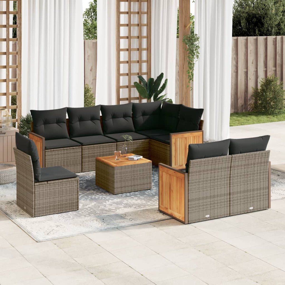 Garten-Sitzgruppe mit grauen Kissen auf einer Terrasse. Enthält ein Ecksofa, einen Stuhl und einen Couchtisch. Weiße Vorhänge im Hintergrund.