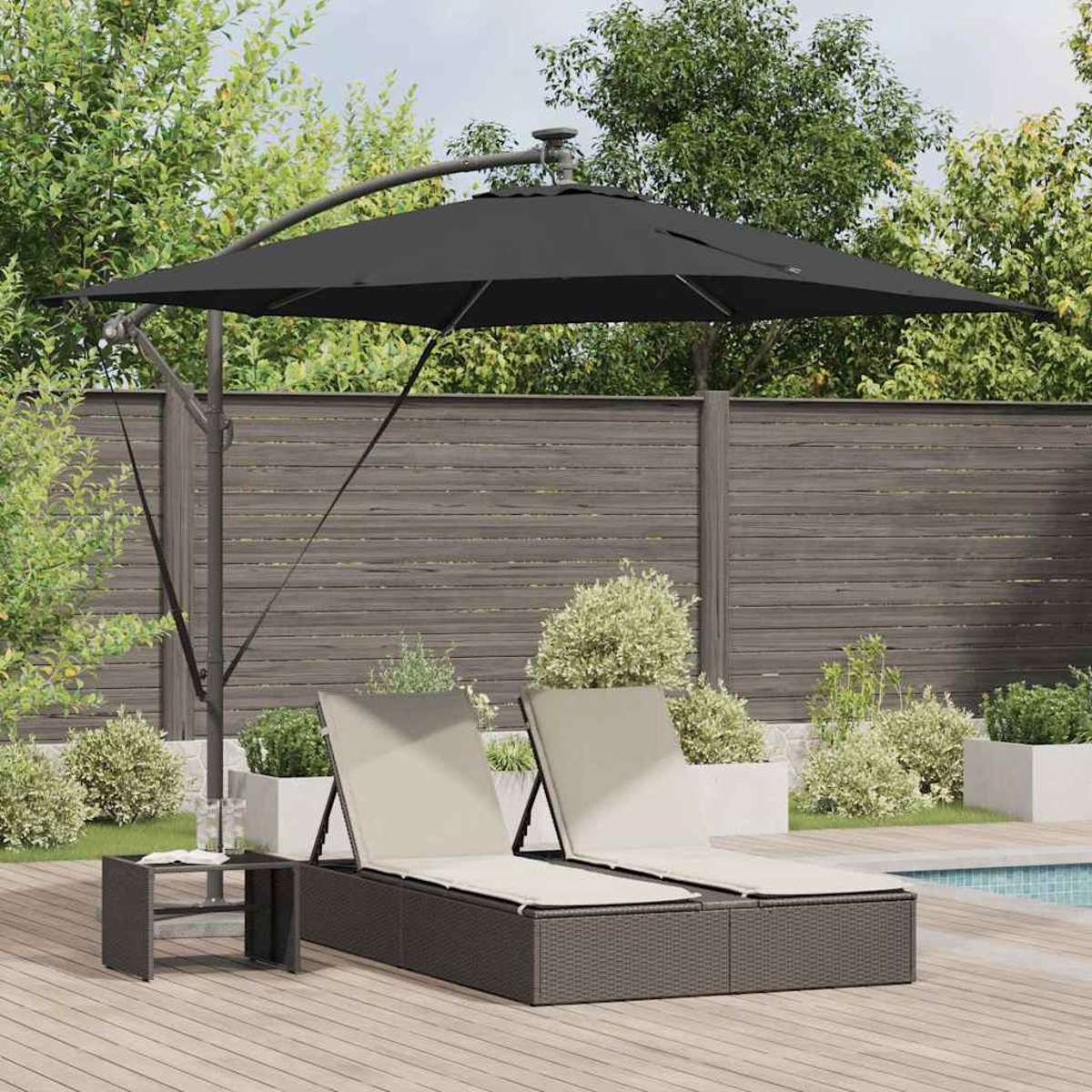 Scena all'aperto con due sedie a sdraio sotto un ombrello nero. Un tavolino a sinistra. Sfondo con alberi, recinzione e piscina.