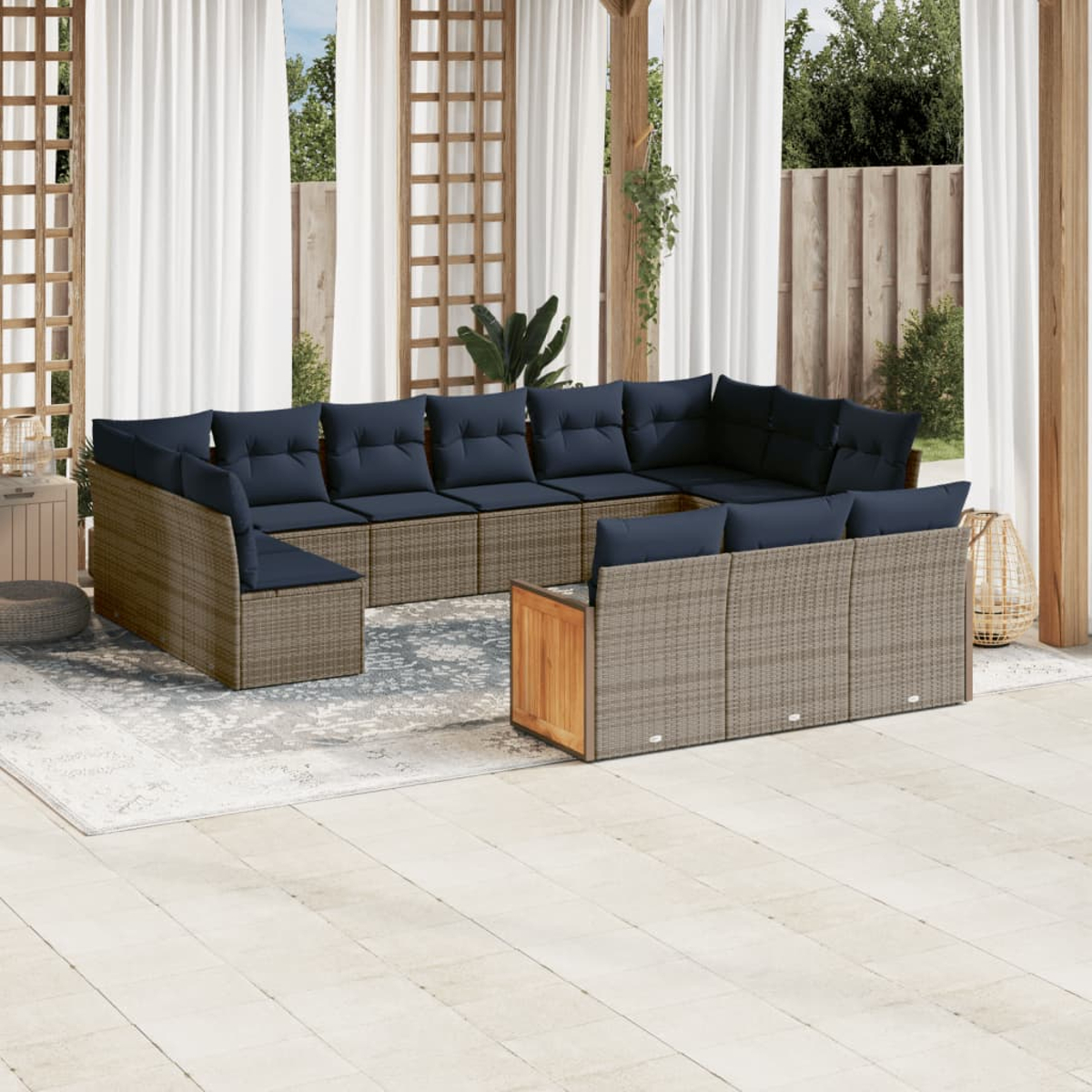 Sofá seccional para exteriores con cojines azul marino. Muebles de mimbre beige en un patio con cortinas y estructura de madera.