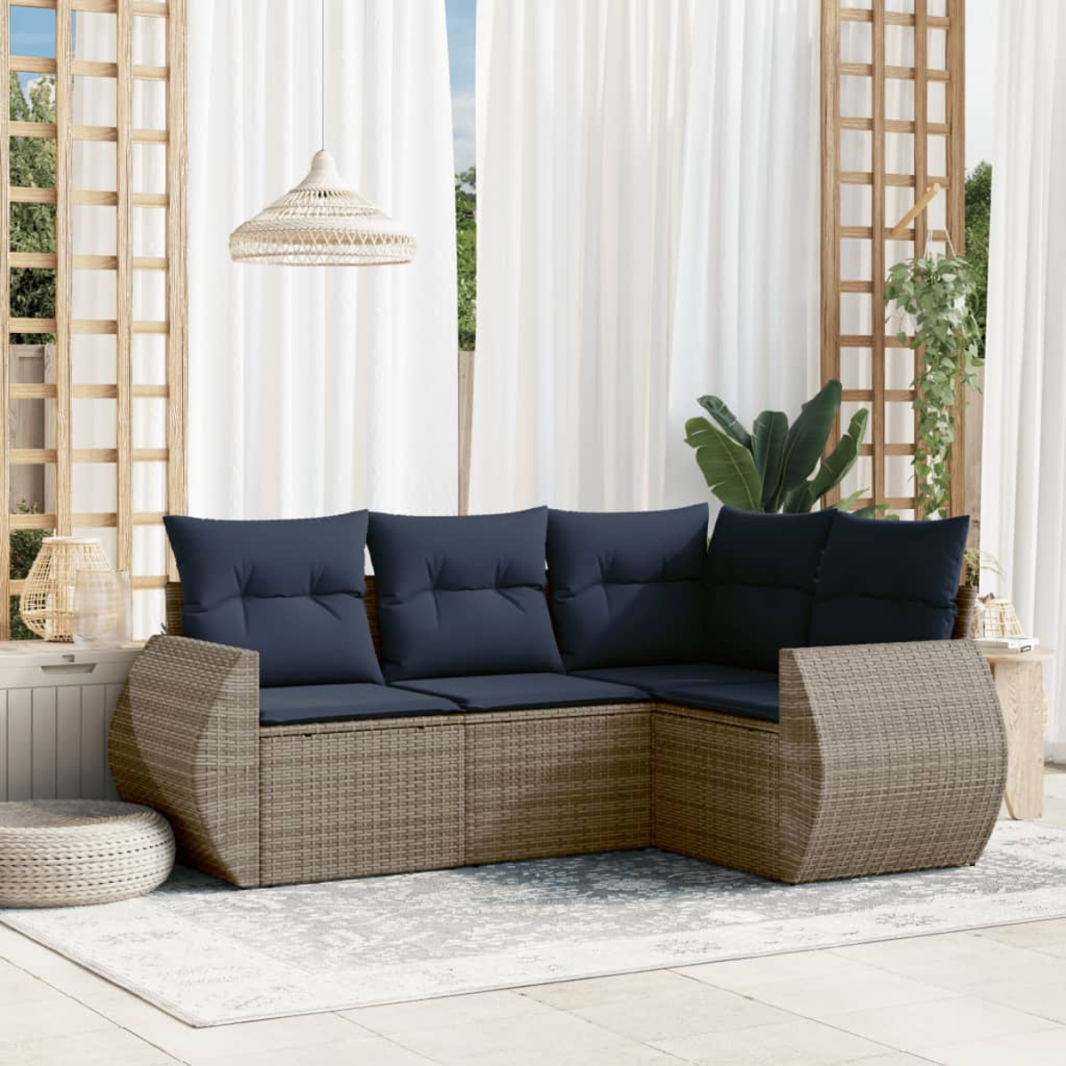 Outdoor-Ecksofa mit marineblauen Kissen. Geflochtene Korbbasis. Weiße Vorhänge im Hintergrund. Hängelampe und ein kleiner Tisch.