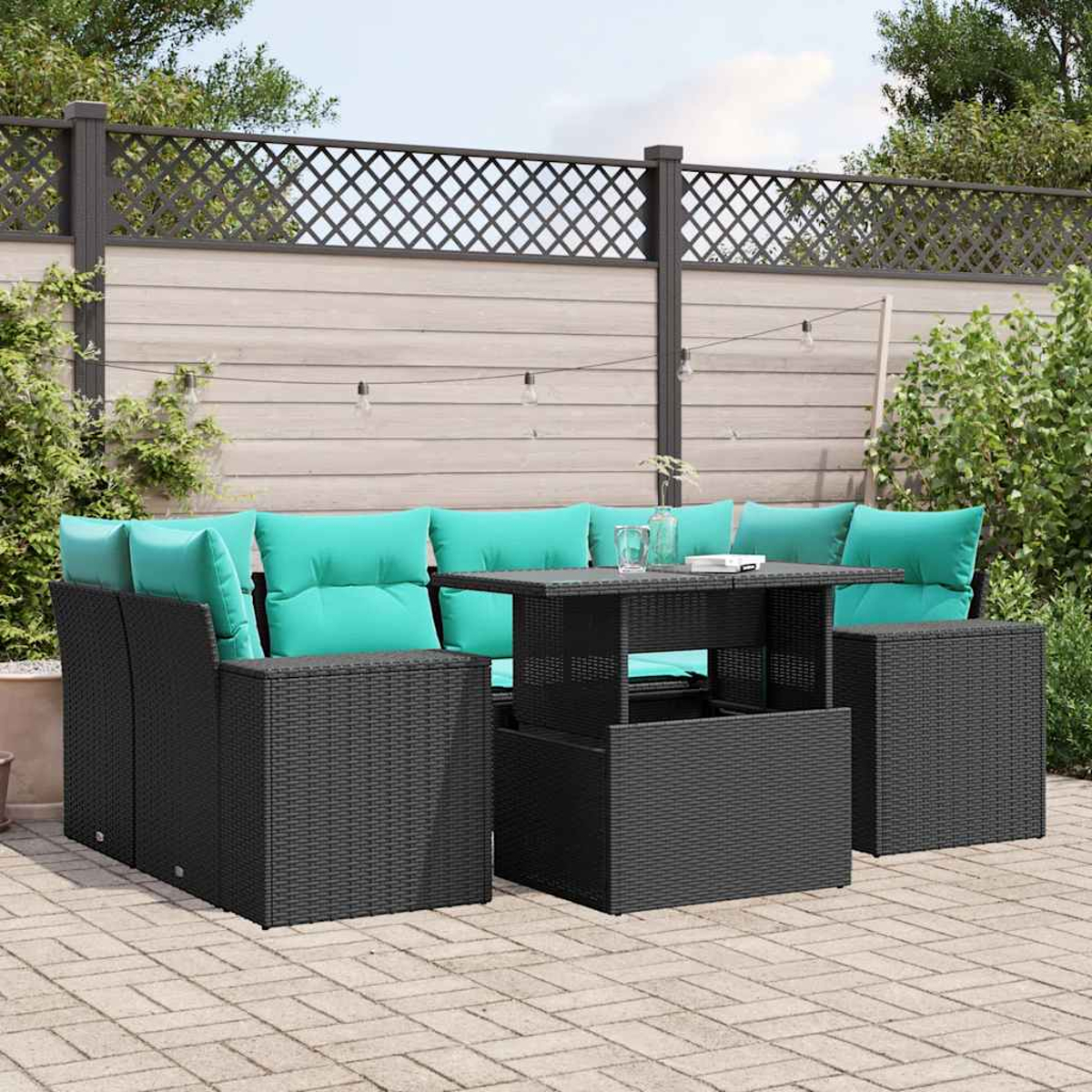 Gartenmöbelset: schwarze gewebte Möbel mit türkisfarbenen Kissen. Enthält einen Tisch und einen Zaun im Hintergrund mit Pflanzen.