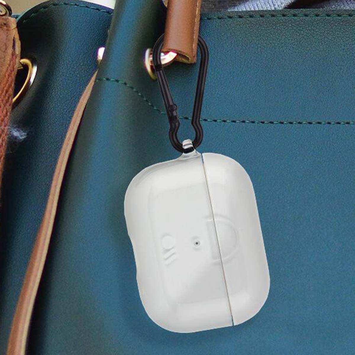 Custodia bianca per AirPods attaccata a un moschettone nero, appesa a un cinturino di una borsa verde acqua.