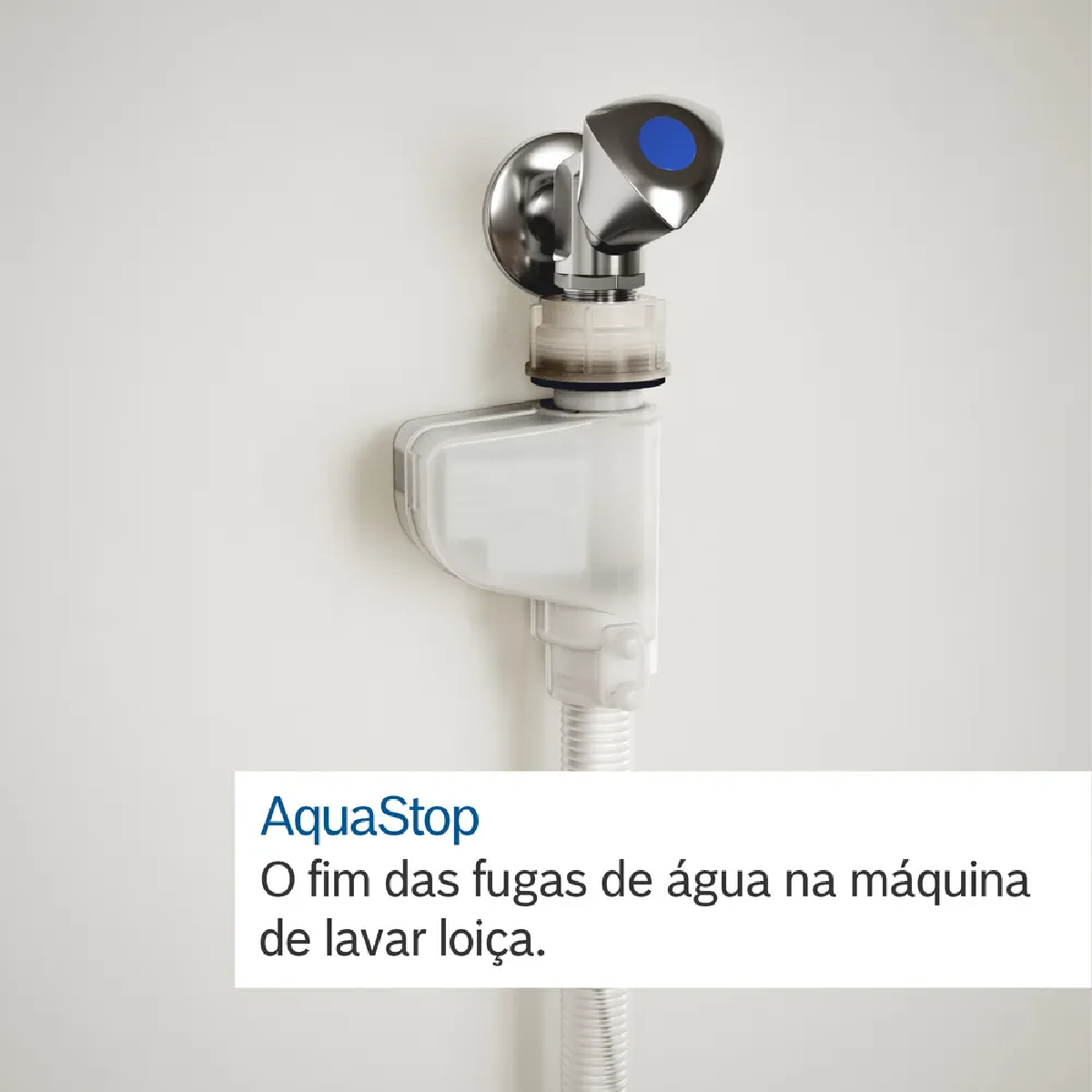 Un dispositivo de cierre de agua, AquaStop, está instalado en una pared blanca. Cuenta con un botón azul y una manguera flexible.