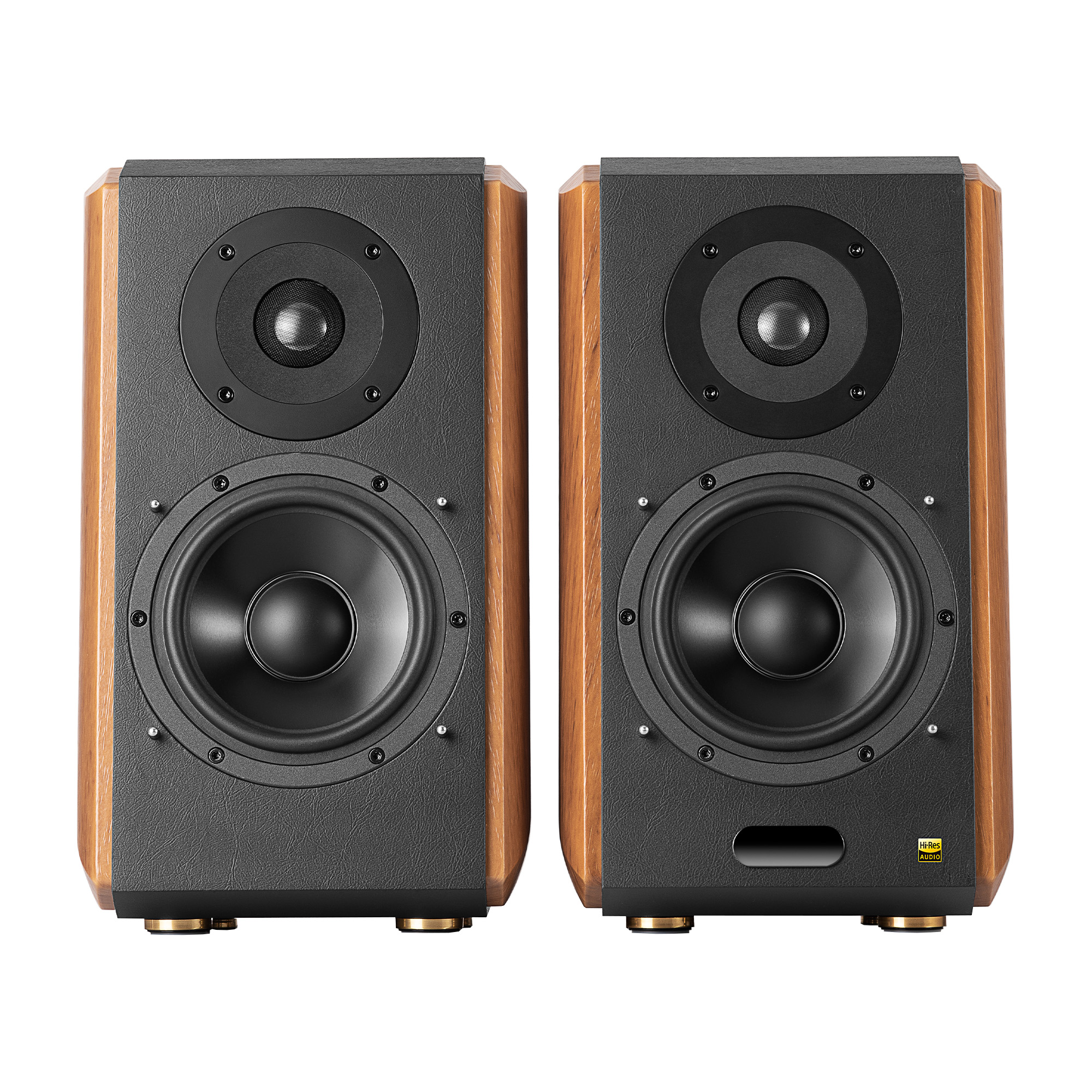Dwa głośniki z czarnymi frontami i drewnianymi bokami. Każdy ma dwa głośniki i złote nóżki. Tło jest białe.