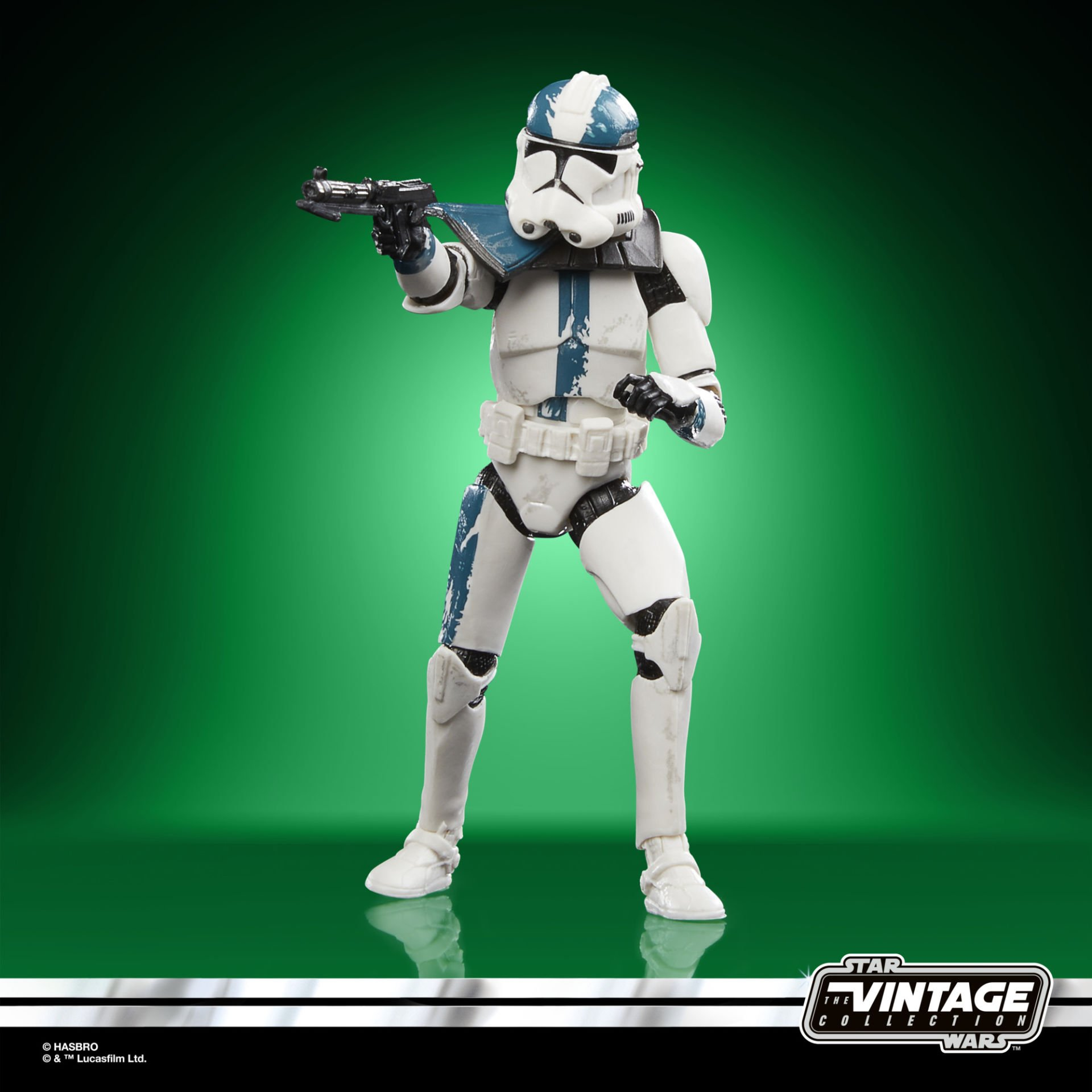 Mavi detaylı beyaz zırhlı bir Star Wars klon askeri aksiyon figürü, bir blaster tutuyor, yeşil bir arka plan üzerinde.